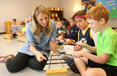 Teacher and student playing a xylophone 