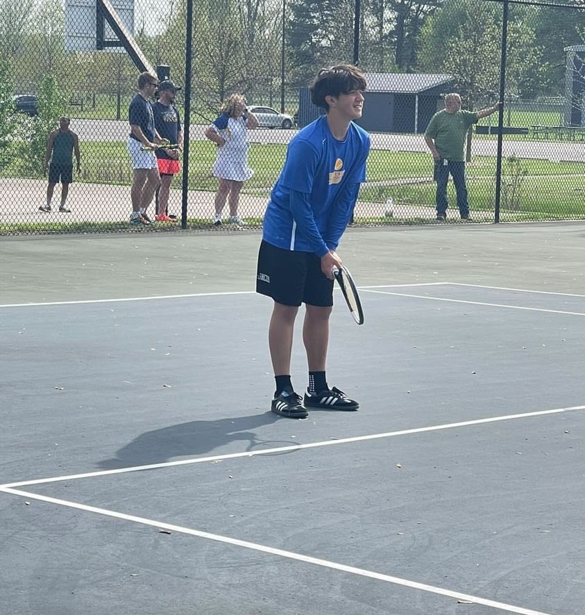 student standing with the racket