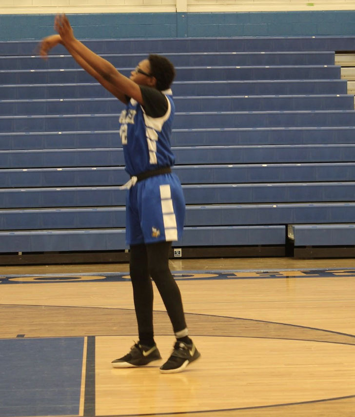 student throwing the ball into the basket