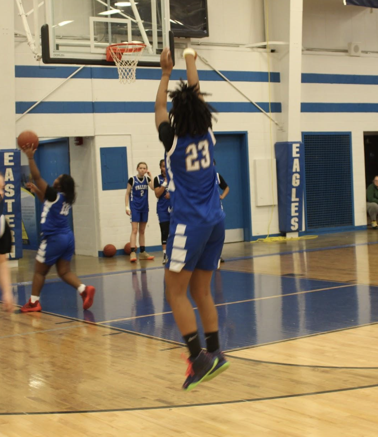 student throwing the ball into the basket