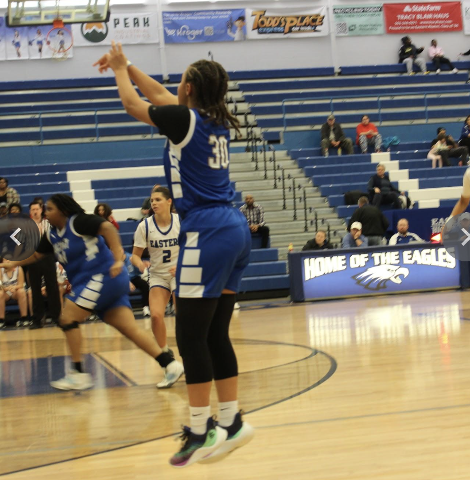 student throwing the ball into the basket