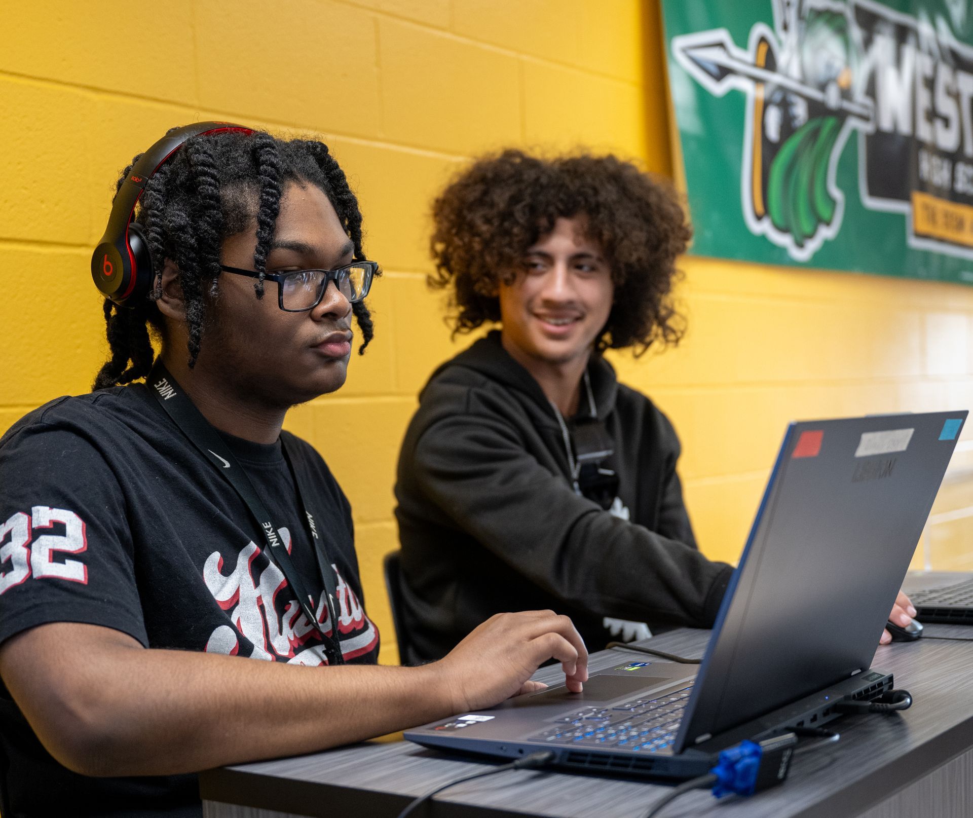 two students sitting down working on a computer