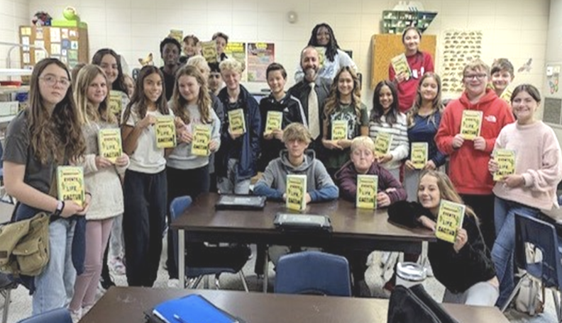 students holding each a notebook at a classroom