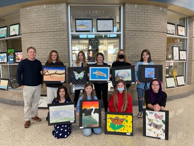 group of students displaying their paintings