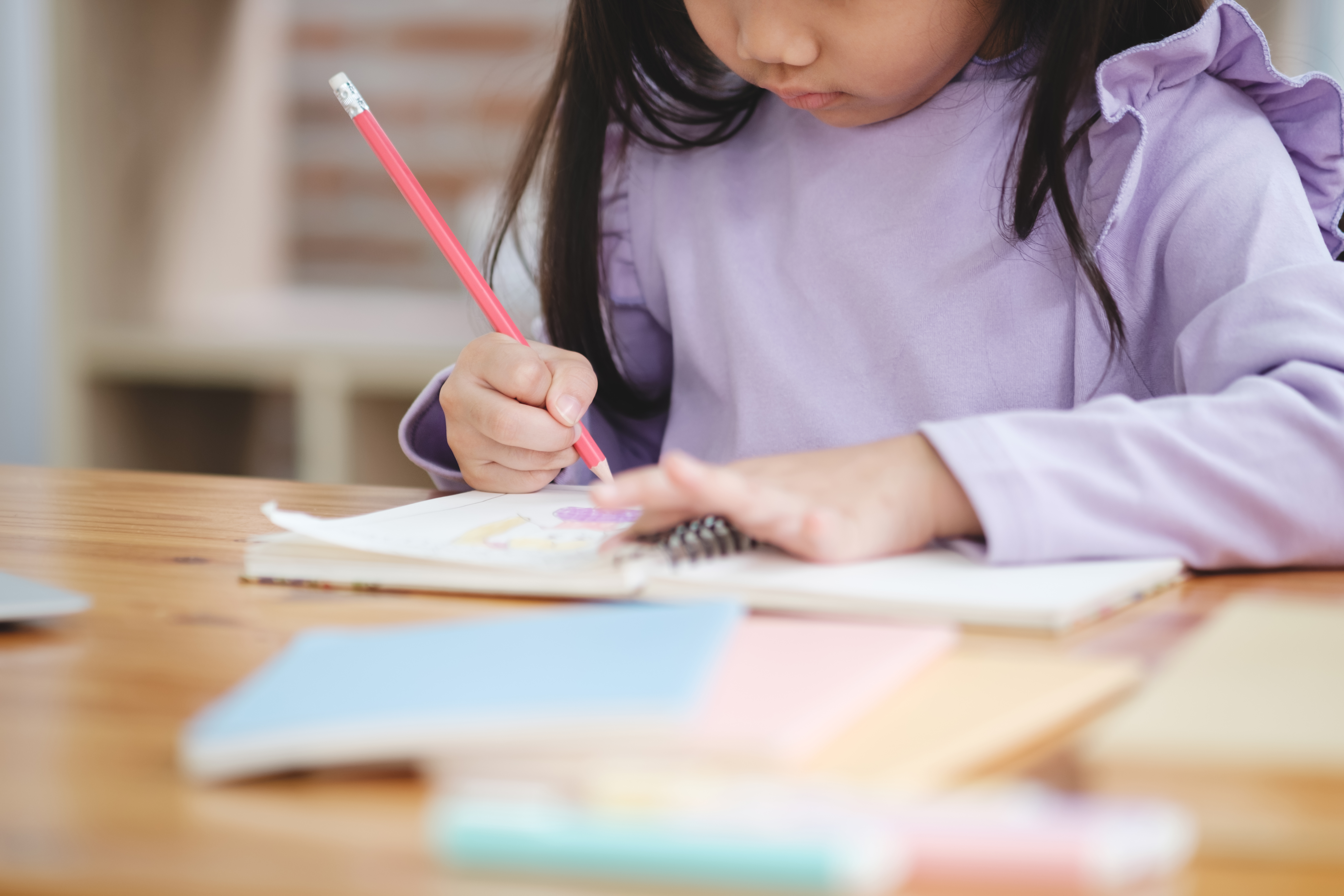 little girl writing in notebook