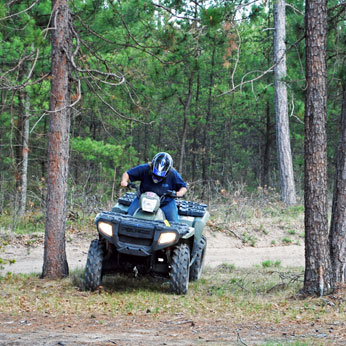 man in a quad bike in the woods