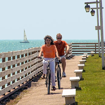 2 people biking on boardwalk