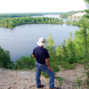 Man on trail looking at lake