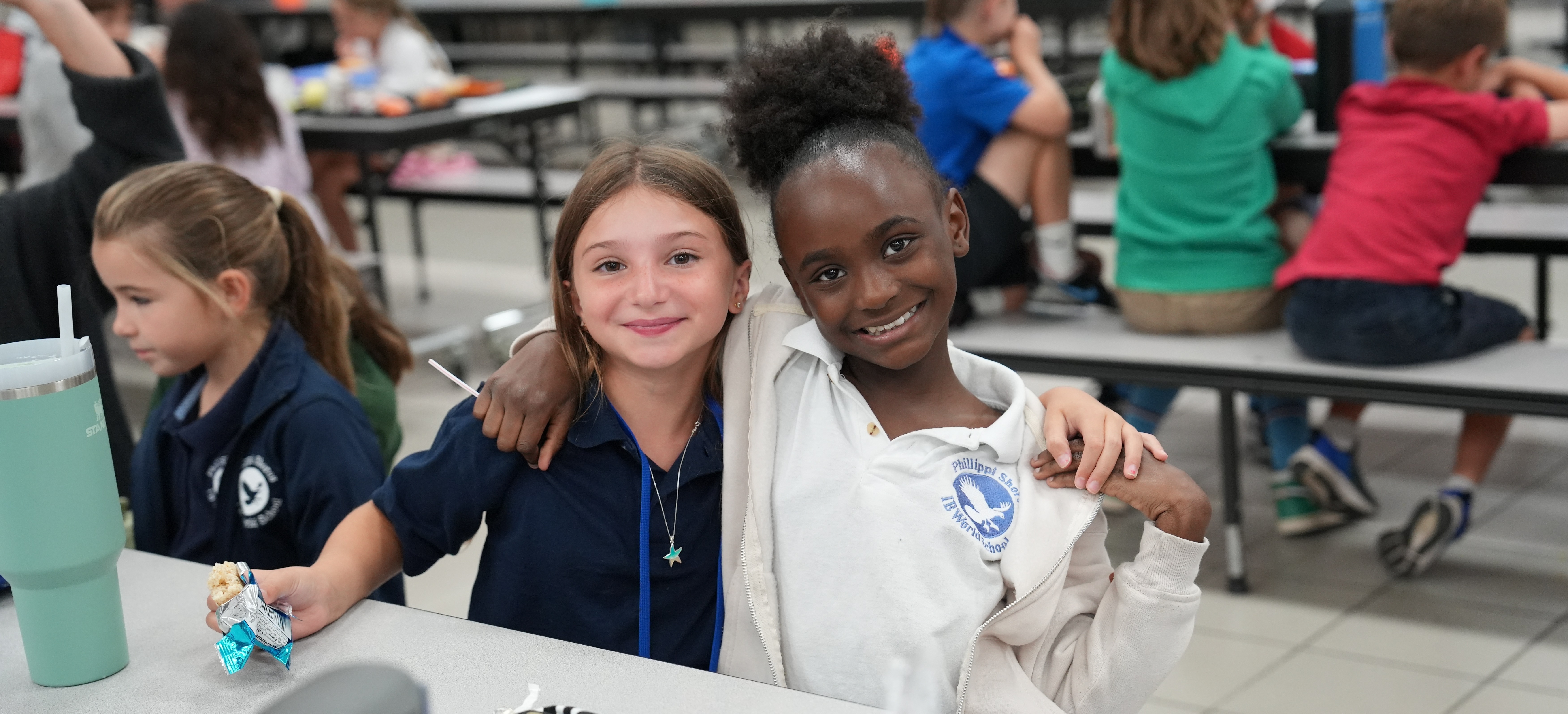 Two Elementary students in the cafeteria wearing a uniform