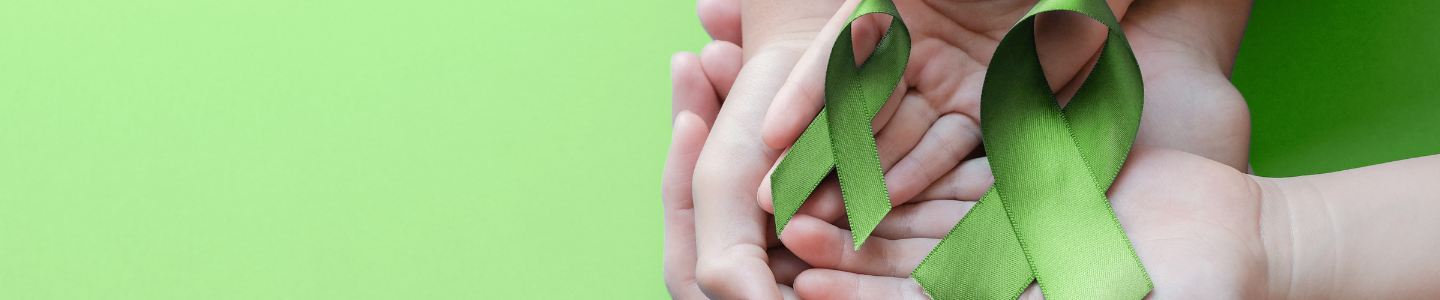 green mental health ribbons in hands