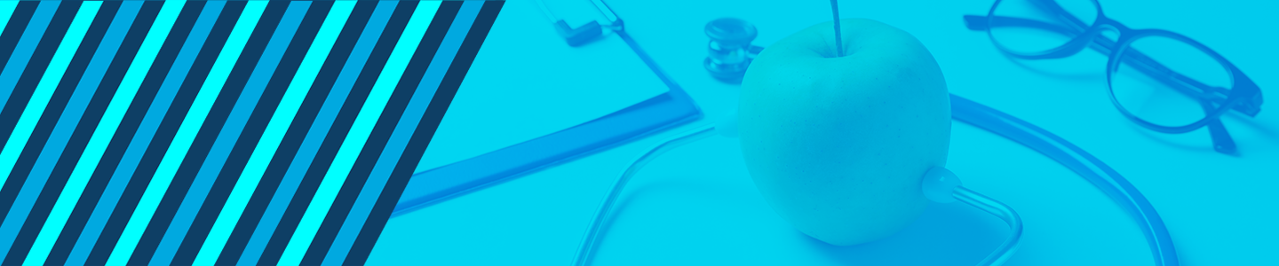 Apple with stethoscope on  a desk with a notepad and glasses