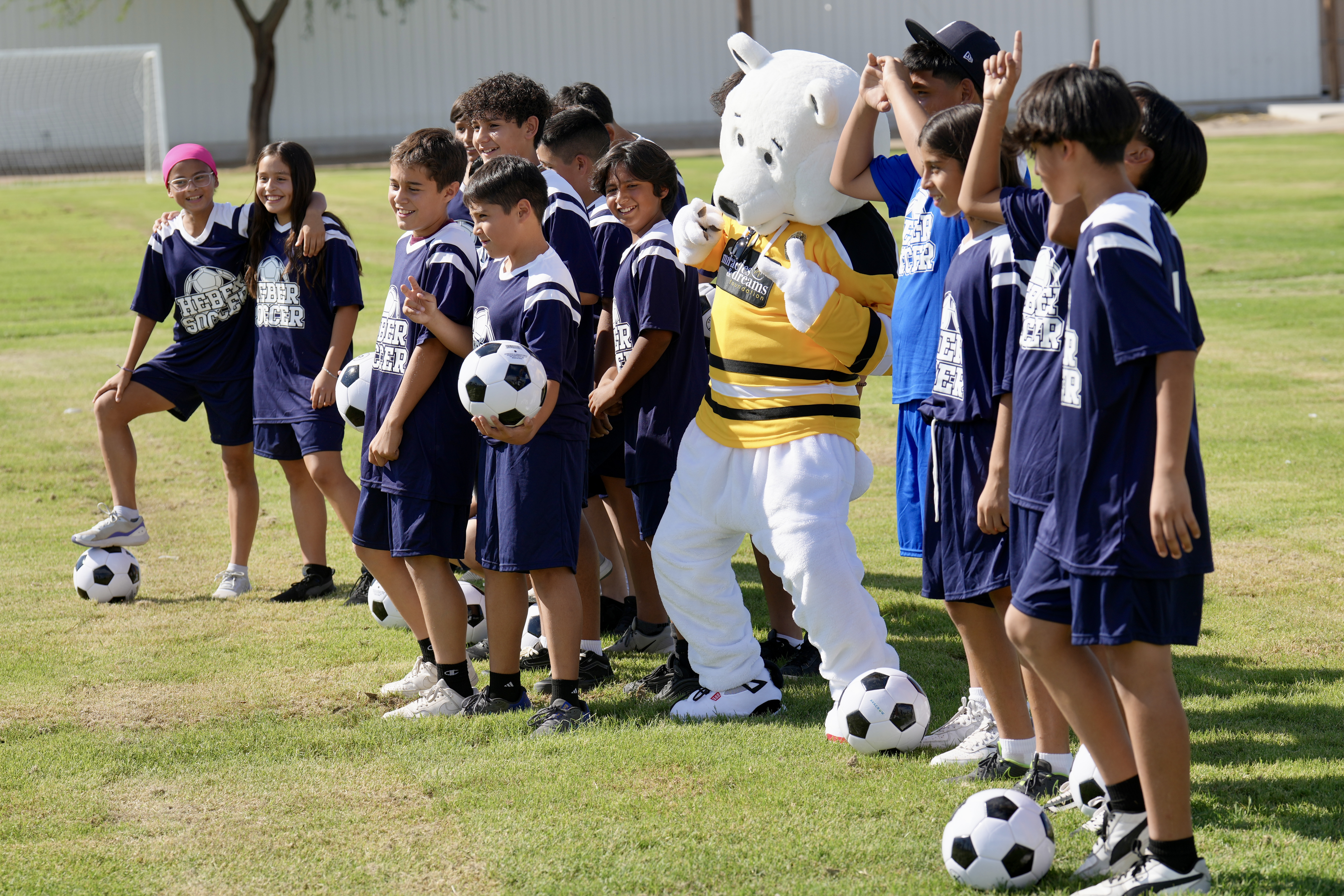 Heber School Soccer Team pictured with the Miracles & Dreams Foundation bear mascot
