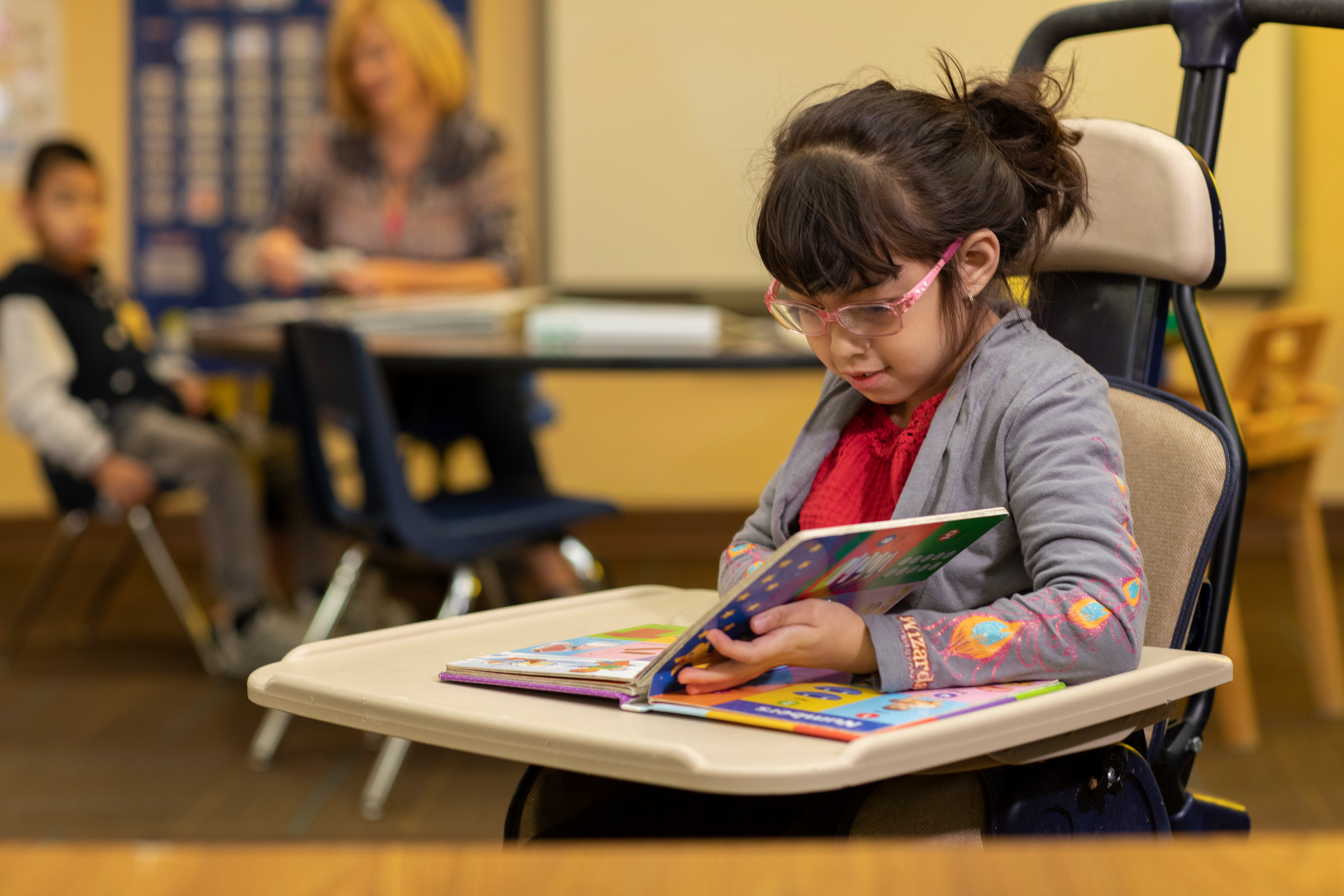 A student reads a book in her wheelchair