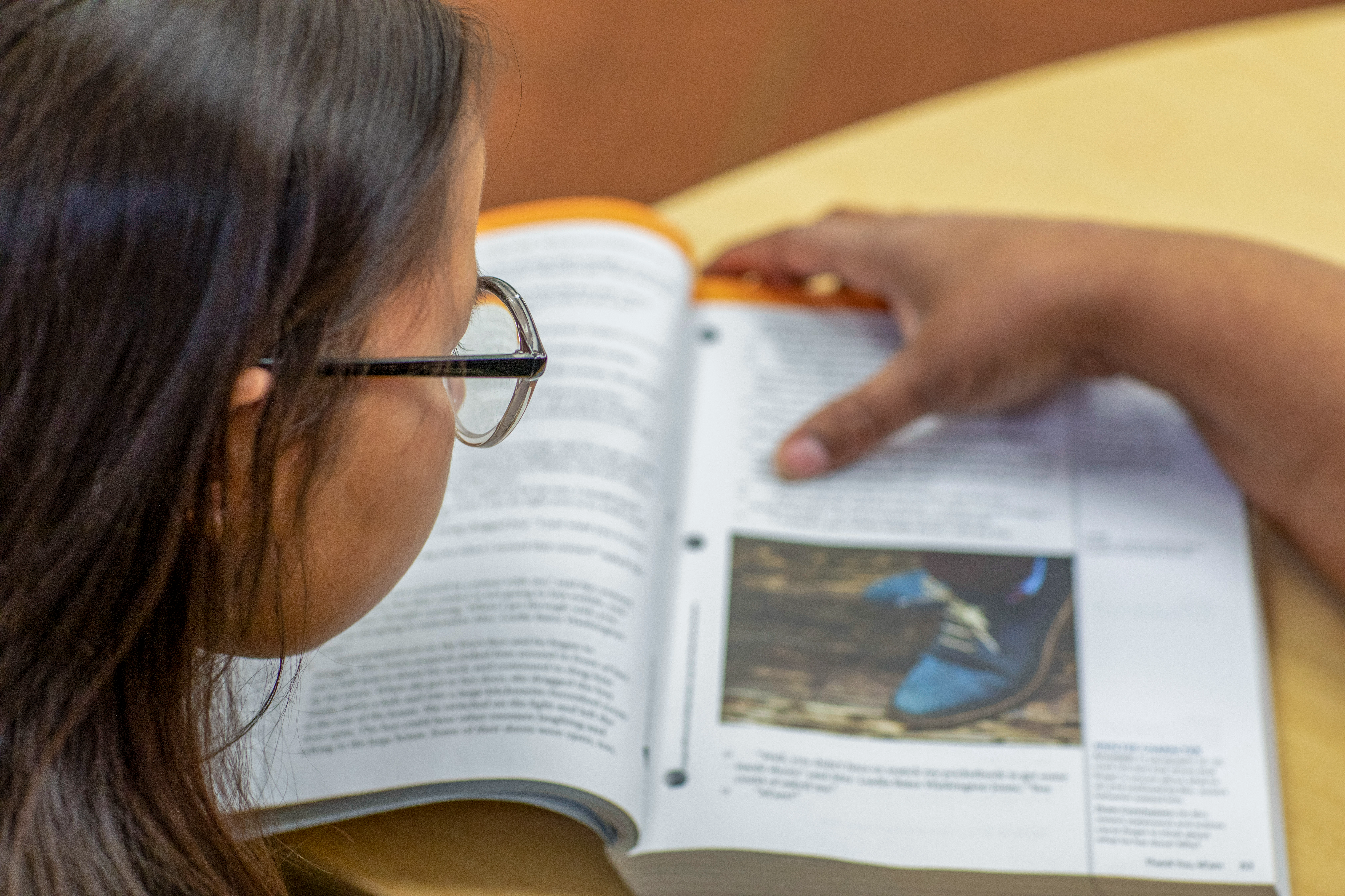 An over-the-shoulder picture of a student reading from a workbook