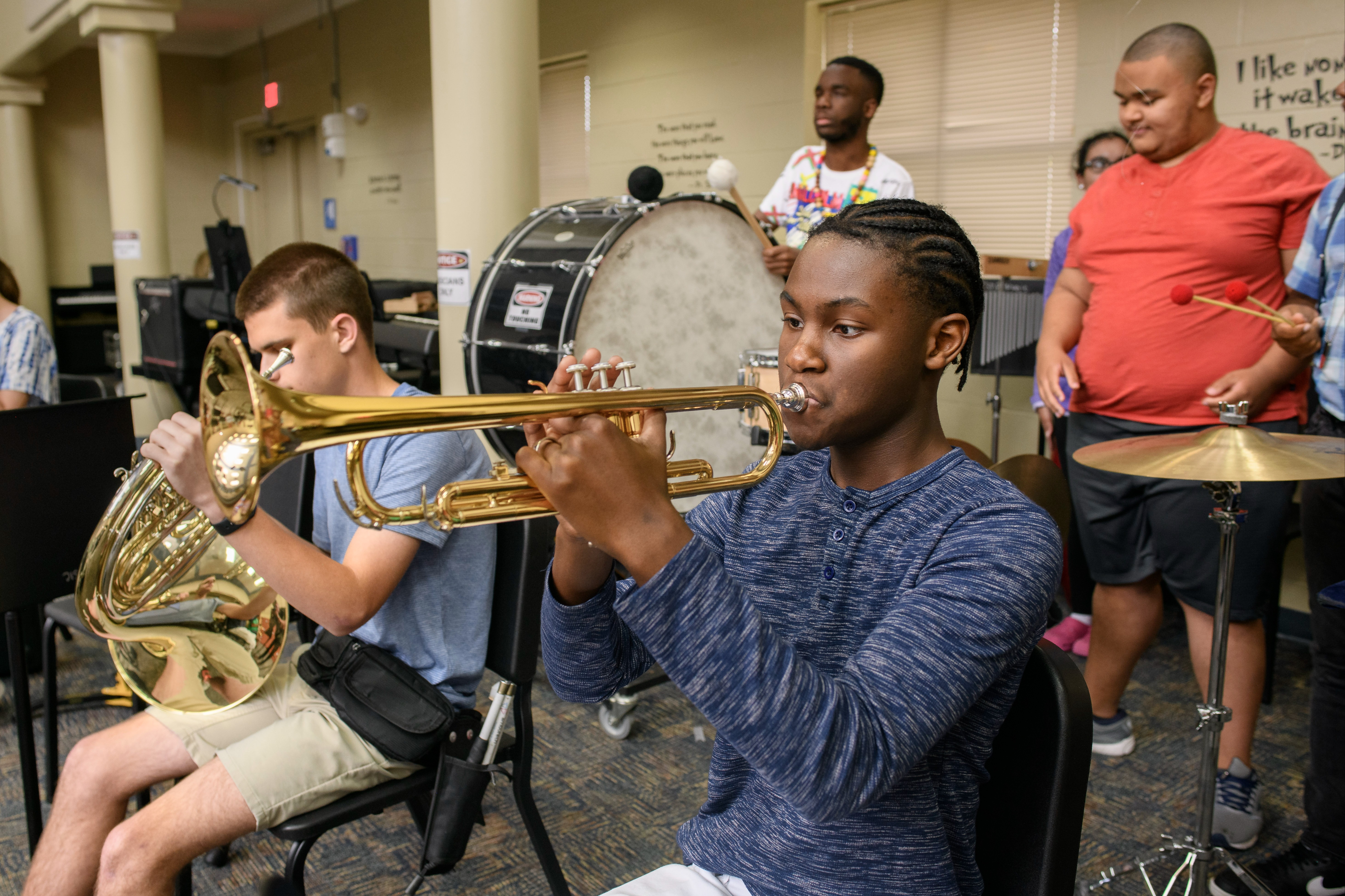 Blind music class with students playing trumpet, french horn and drums.