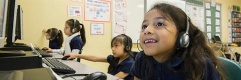 Children in a computer lab wearing headphones and looking at computer screens. The caption reads, "The average child between 8 and 18 spends 53 hours a week with media and technology."