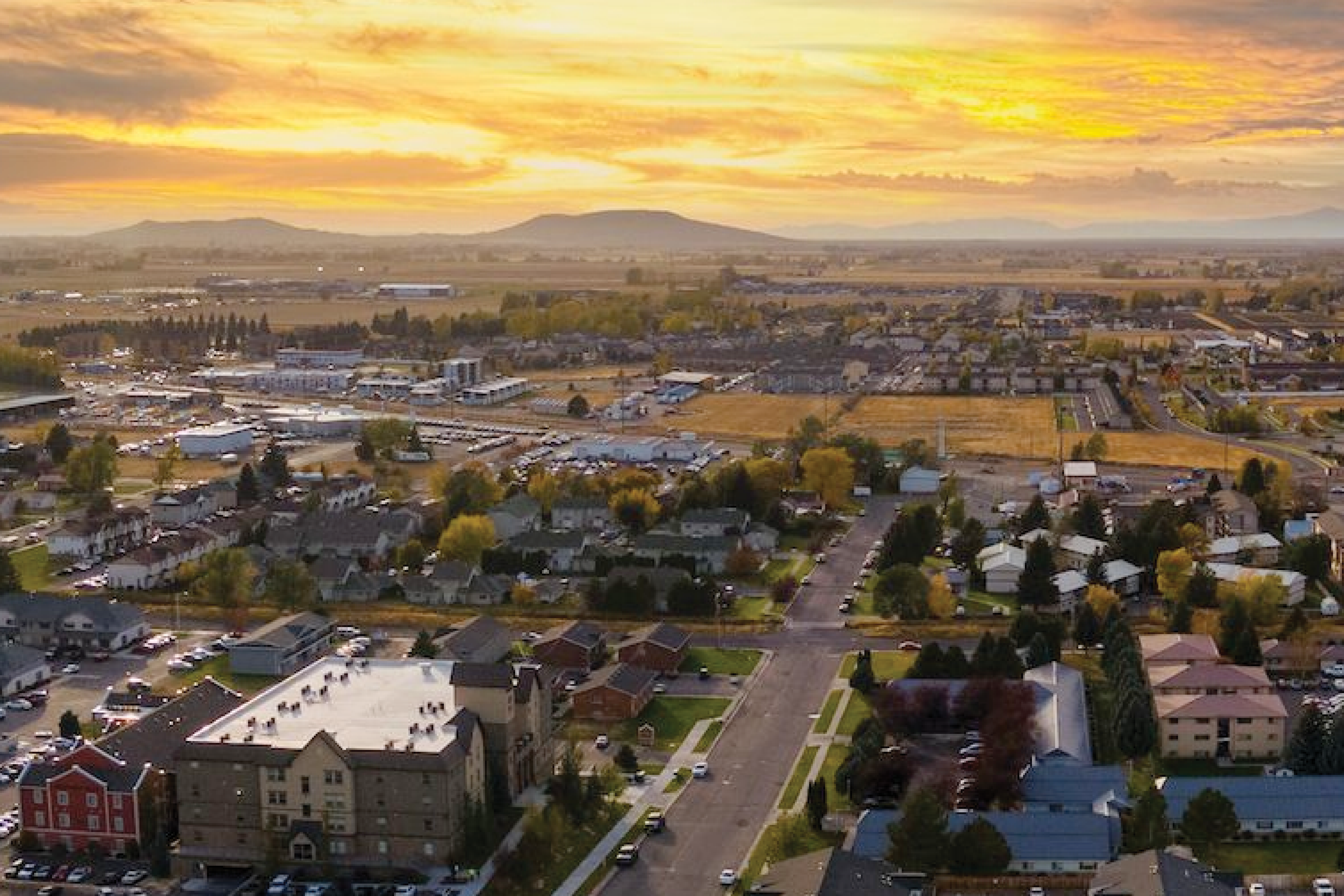 Aerial shot of Rexburg in summer with R-mountain and sunset in the background.