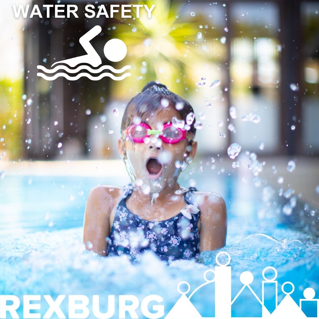 Girl with goggles taking a breath before going under water in a pool