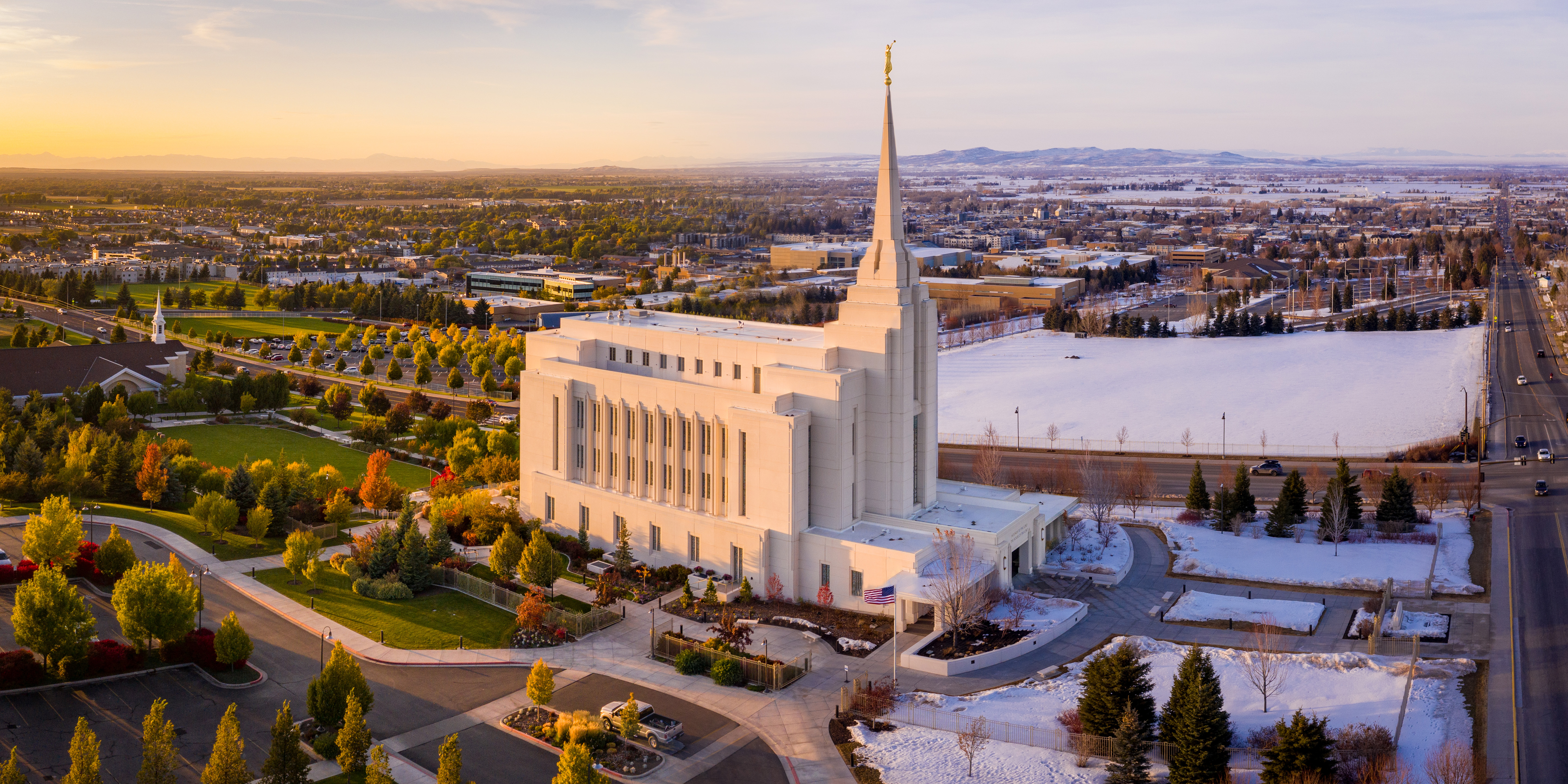 Rexburg LDS Temple is the center of the image with a snow-covered winter scene on the right and green blooming summer on the left