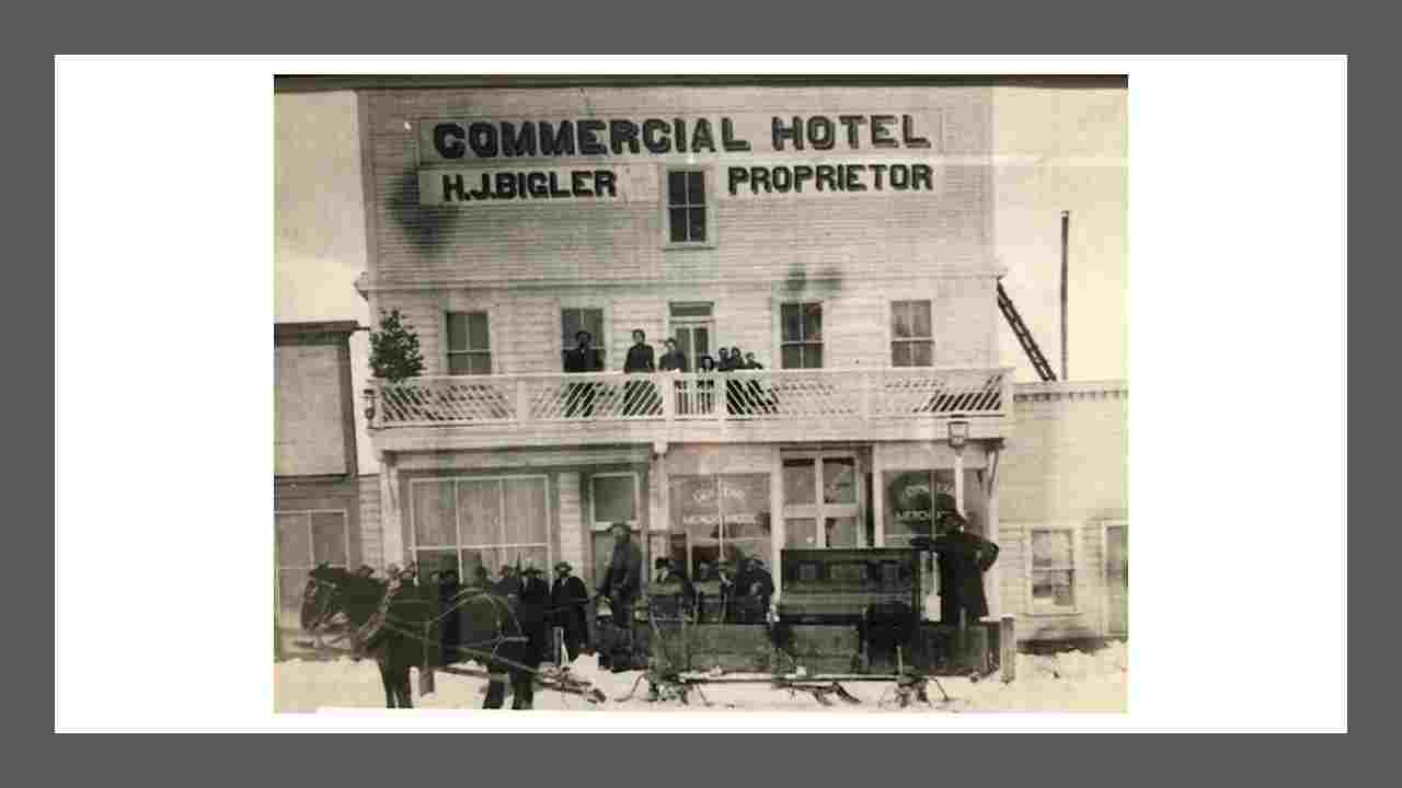Historical Photo of the Rexburg Commercial Hotel with a stage wagon and people out front on the porch and 2nd floor balcony