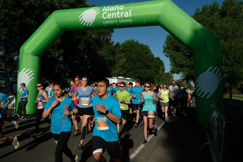 Lots of Runners beginning the Teton Dam Marathon under a green blown-up arch from Idaho Central CU