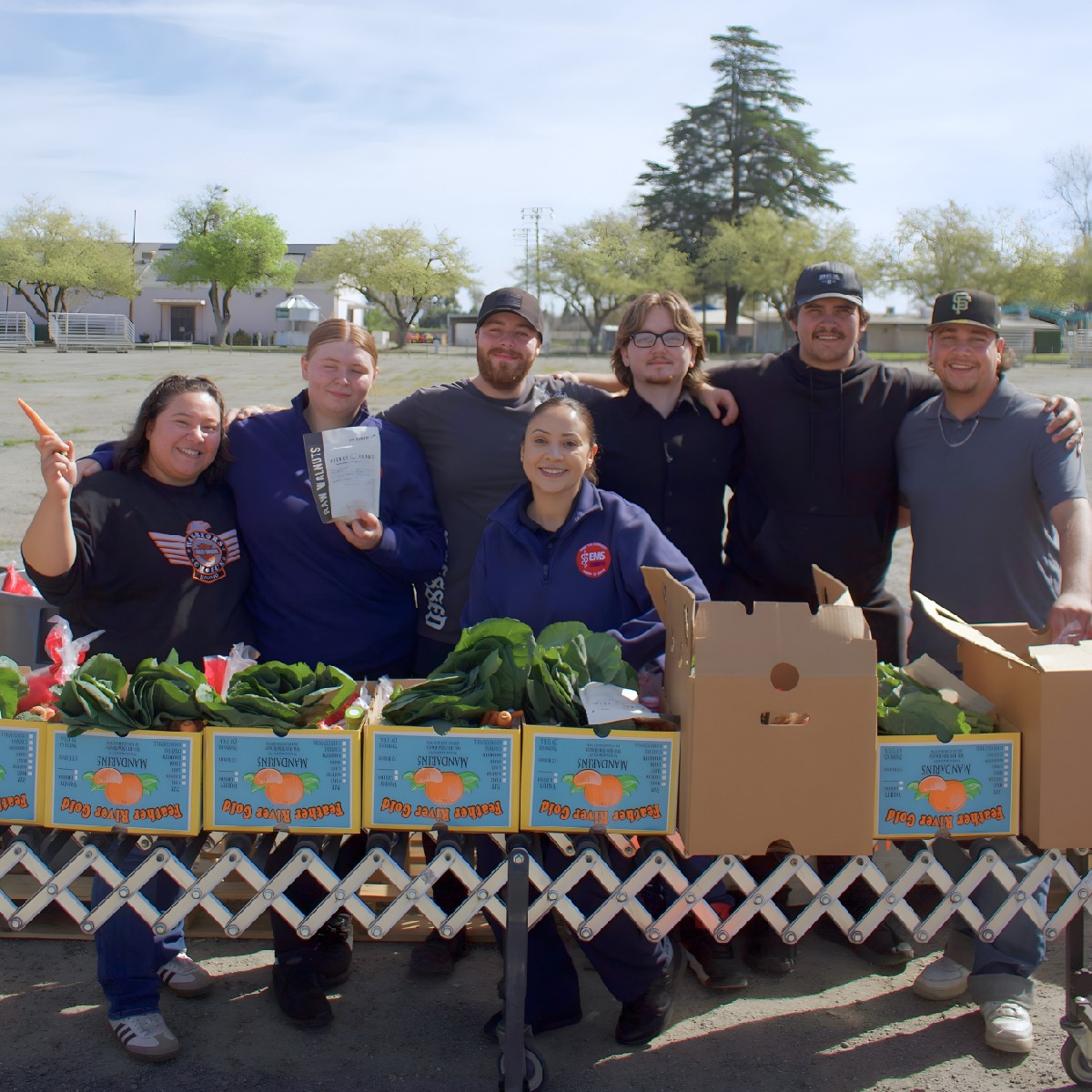group of volunteers at food distribution table holding fresh produce