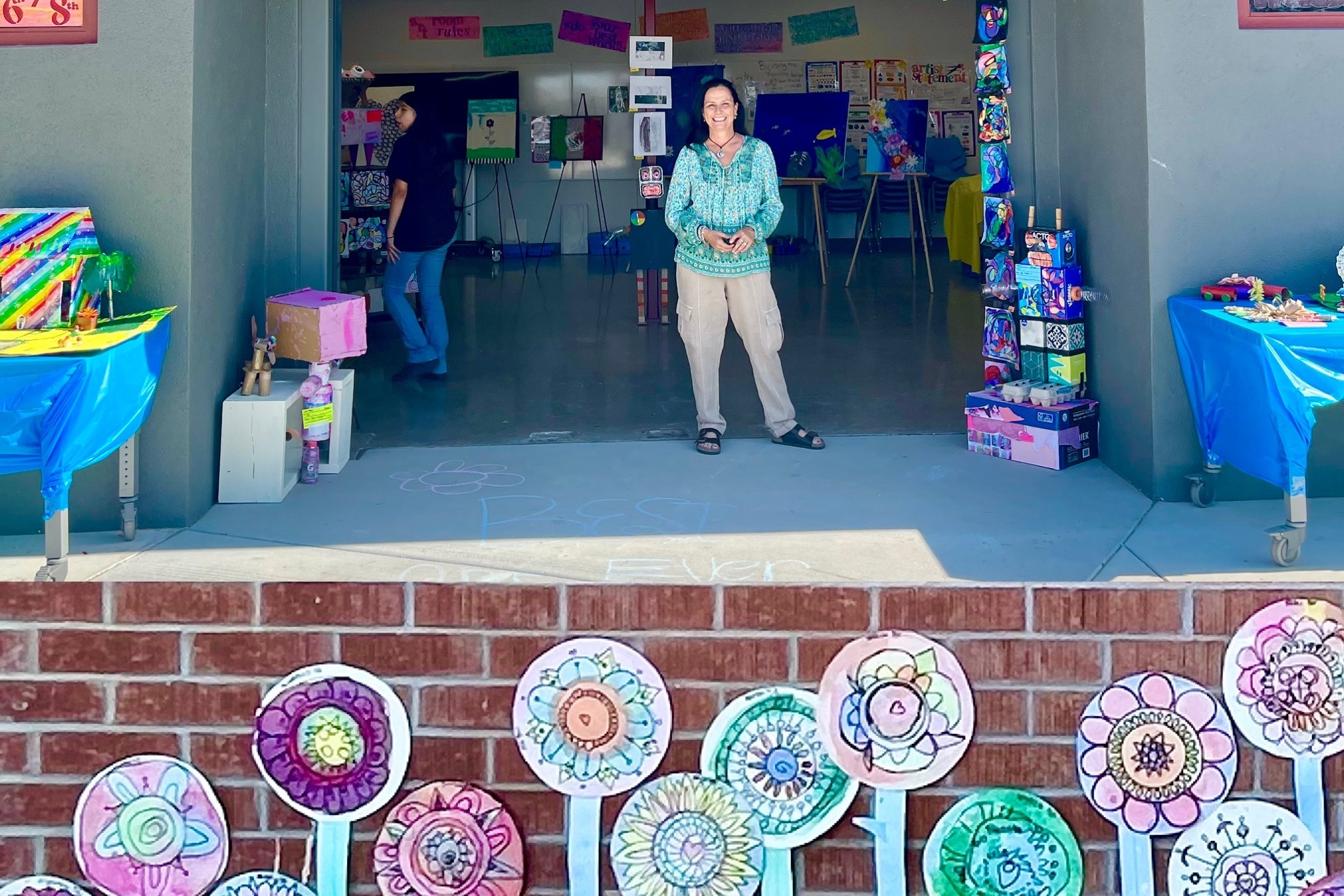 Ms. Garmon in front of the art room with Student artwork flowers in front of her