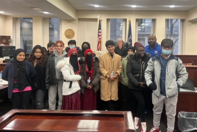 paralegal students pose with judge in courtroom