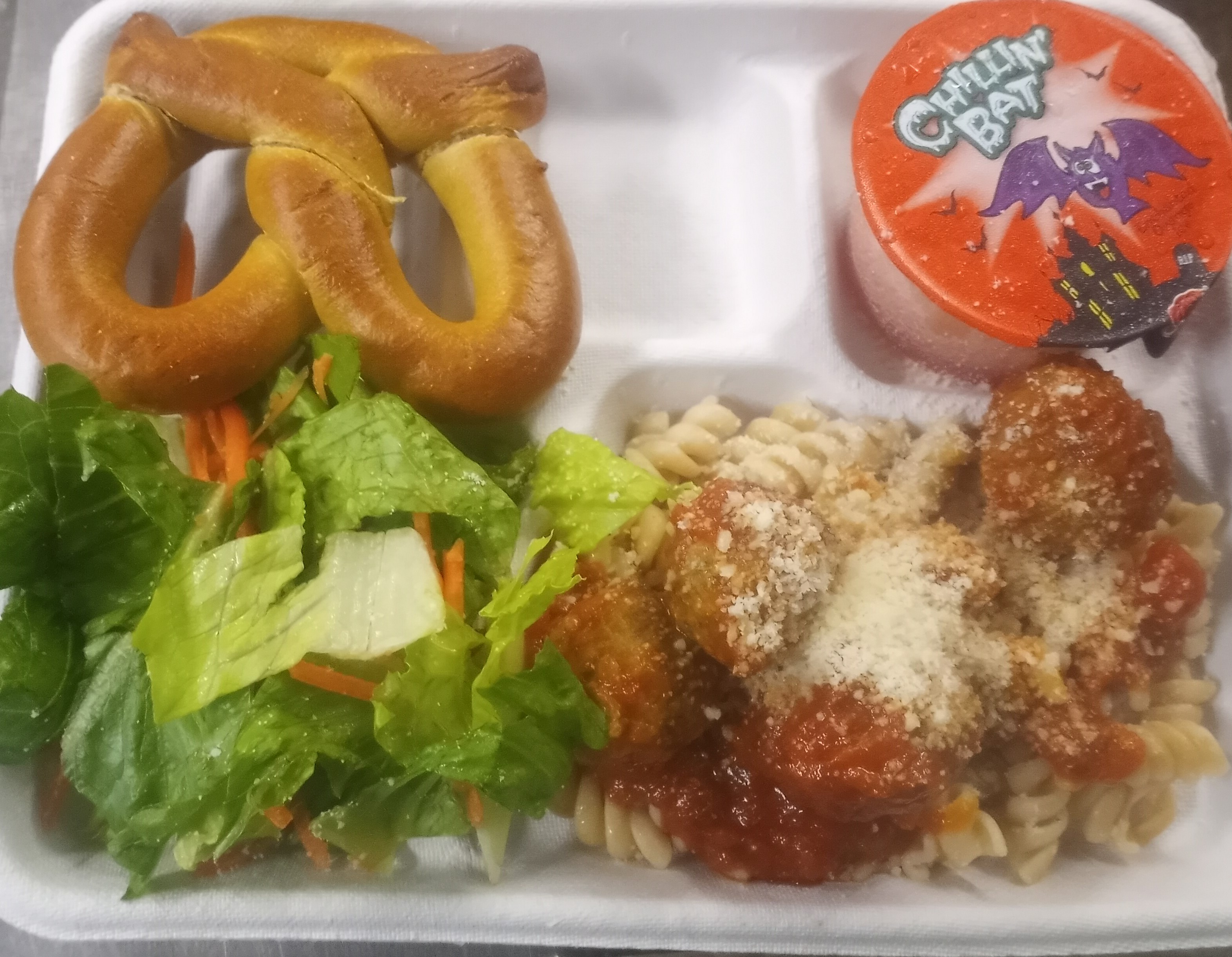 School 207- Lunch served on 10.31.2024 Meatballs over noodle, pretzel, salad & Juice