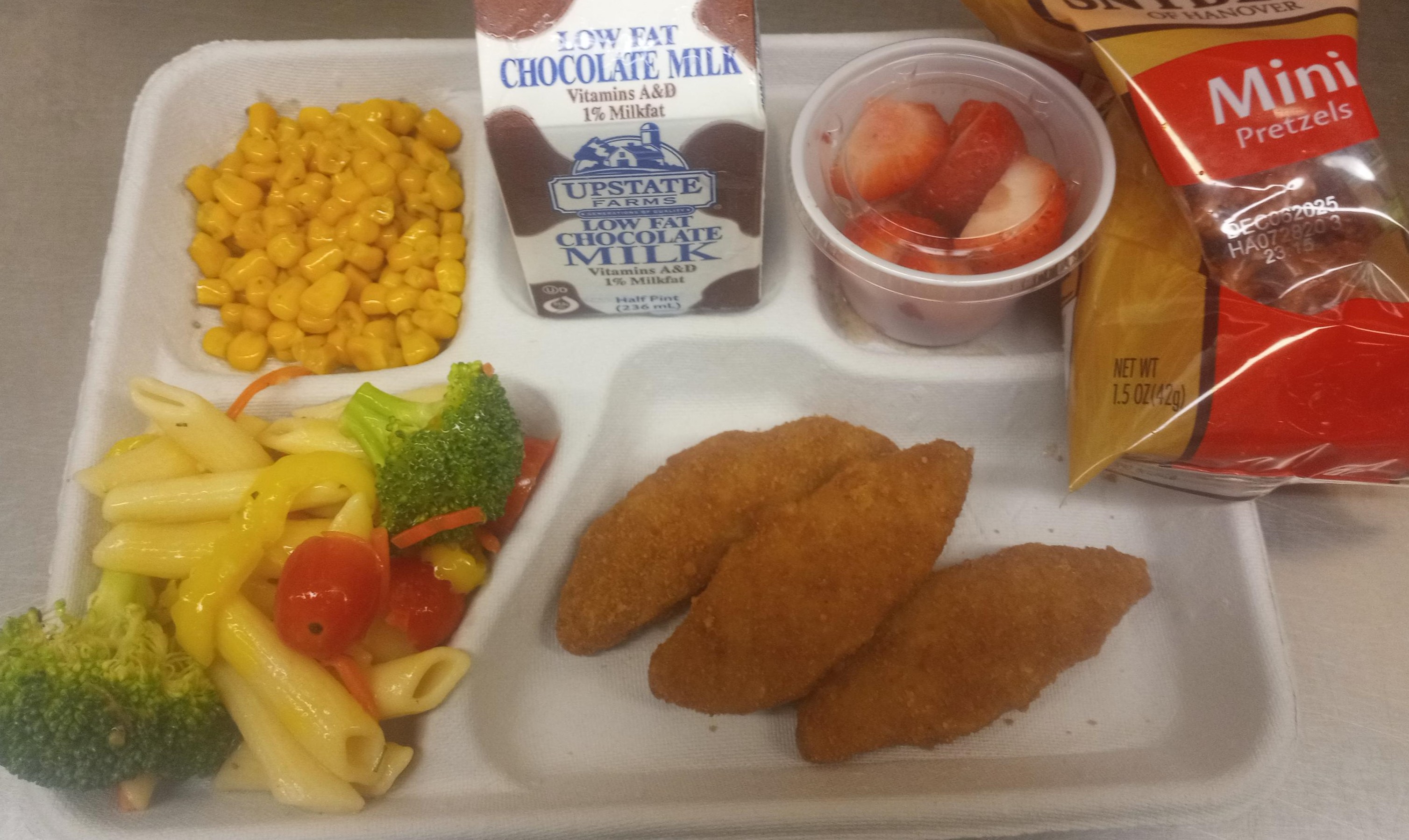 School #15 - Lunch served on 9.17.25 Plant Based Chicken Tenders, Pasta Salad, Sweet Corn, Pretzels, Strawberries & Chocolate Milk