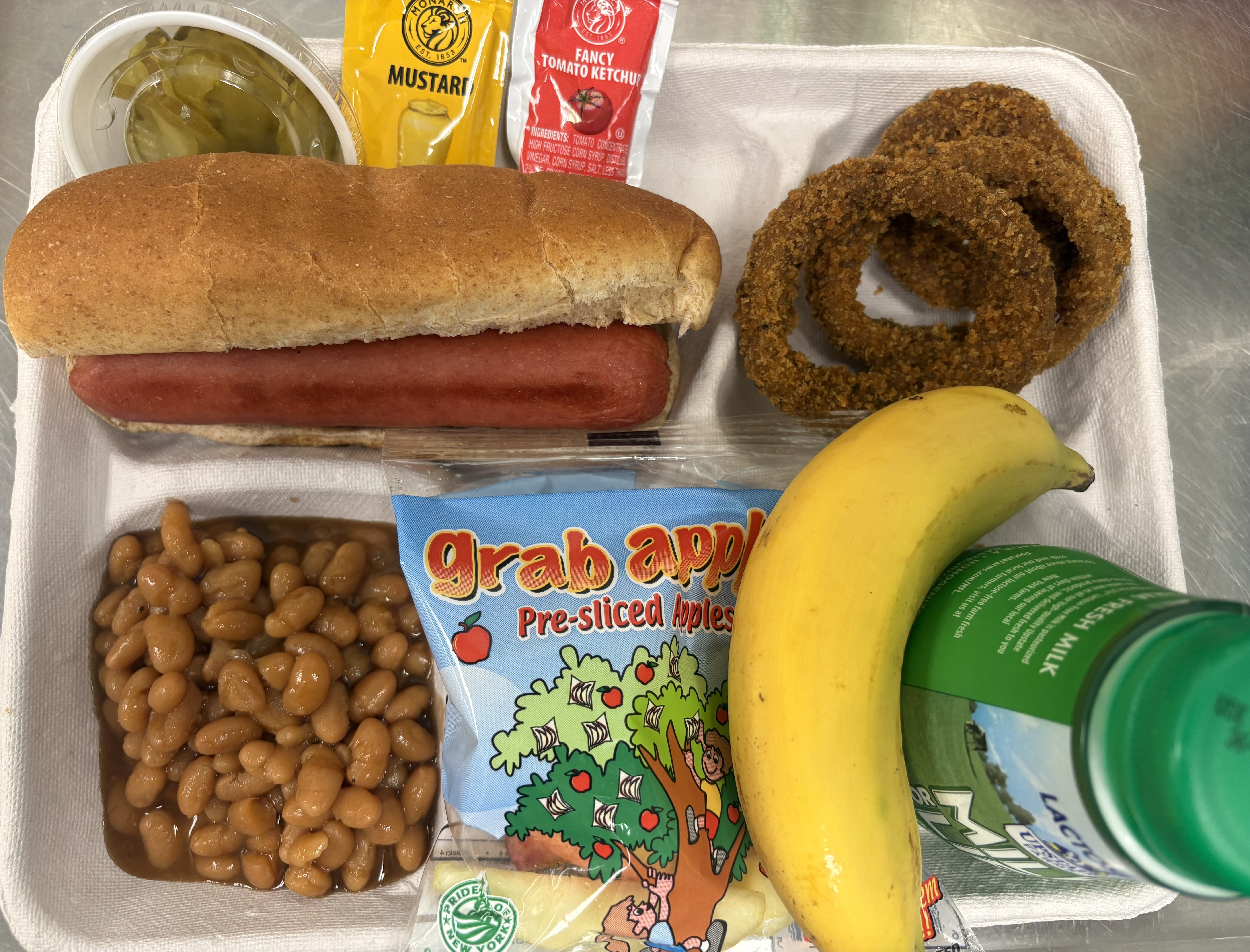School 50 - Lunch served on 10.1.25 Hot Dog, Onion Rings, Baked beans, Apple slices, Banana & Milk