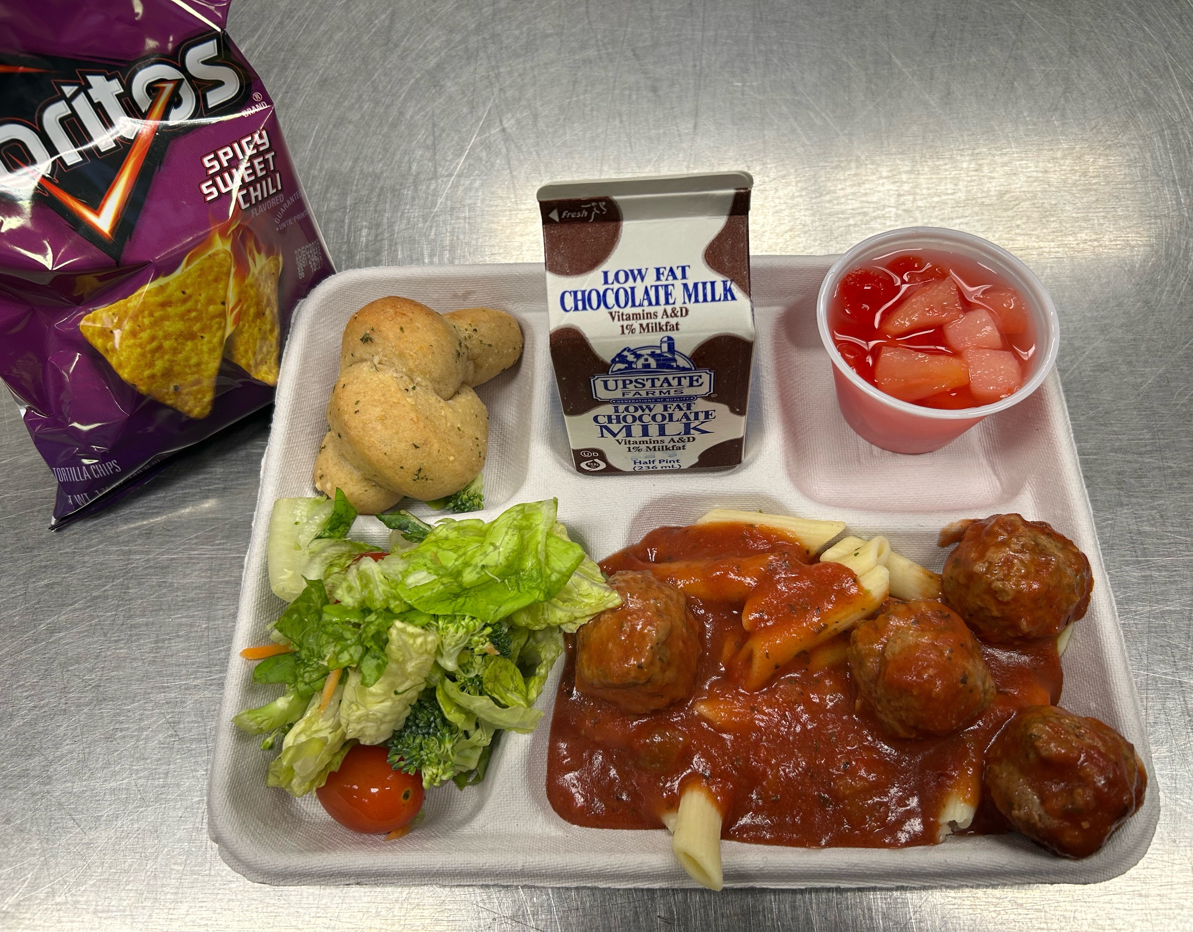 Lunch served 10.3.2025 Penne pasta with Meatballs & Marinara, Garden salad, Garlic Knots, Fruit Cocktail, Doritos & Chocolate Milk