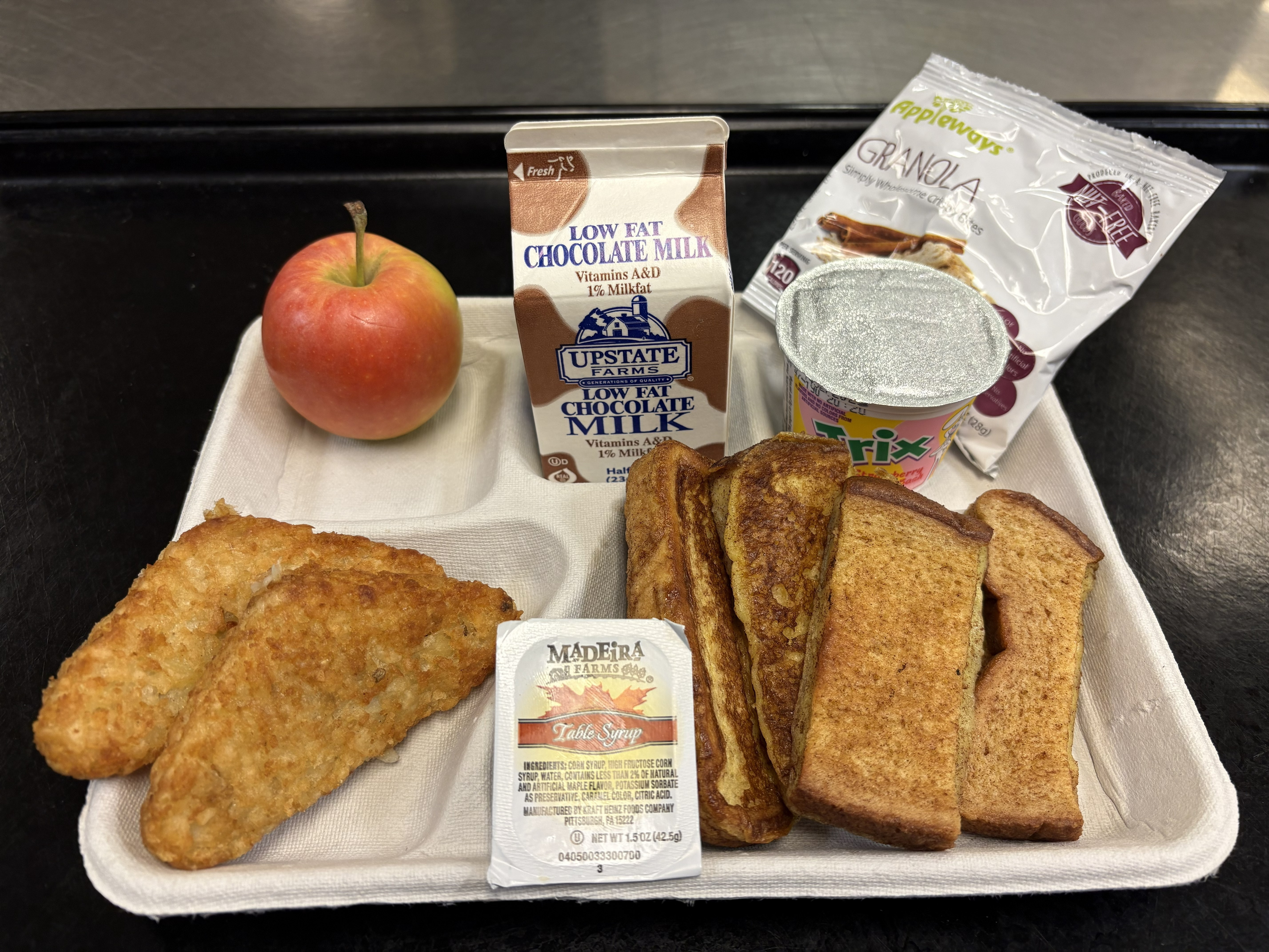 School 72- Lunch served 10.6.2025 French Toast Sticks, Maple Syrup, Hashbrown, Cinnamon Granola Bites, Apple & Chocolate Milk