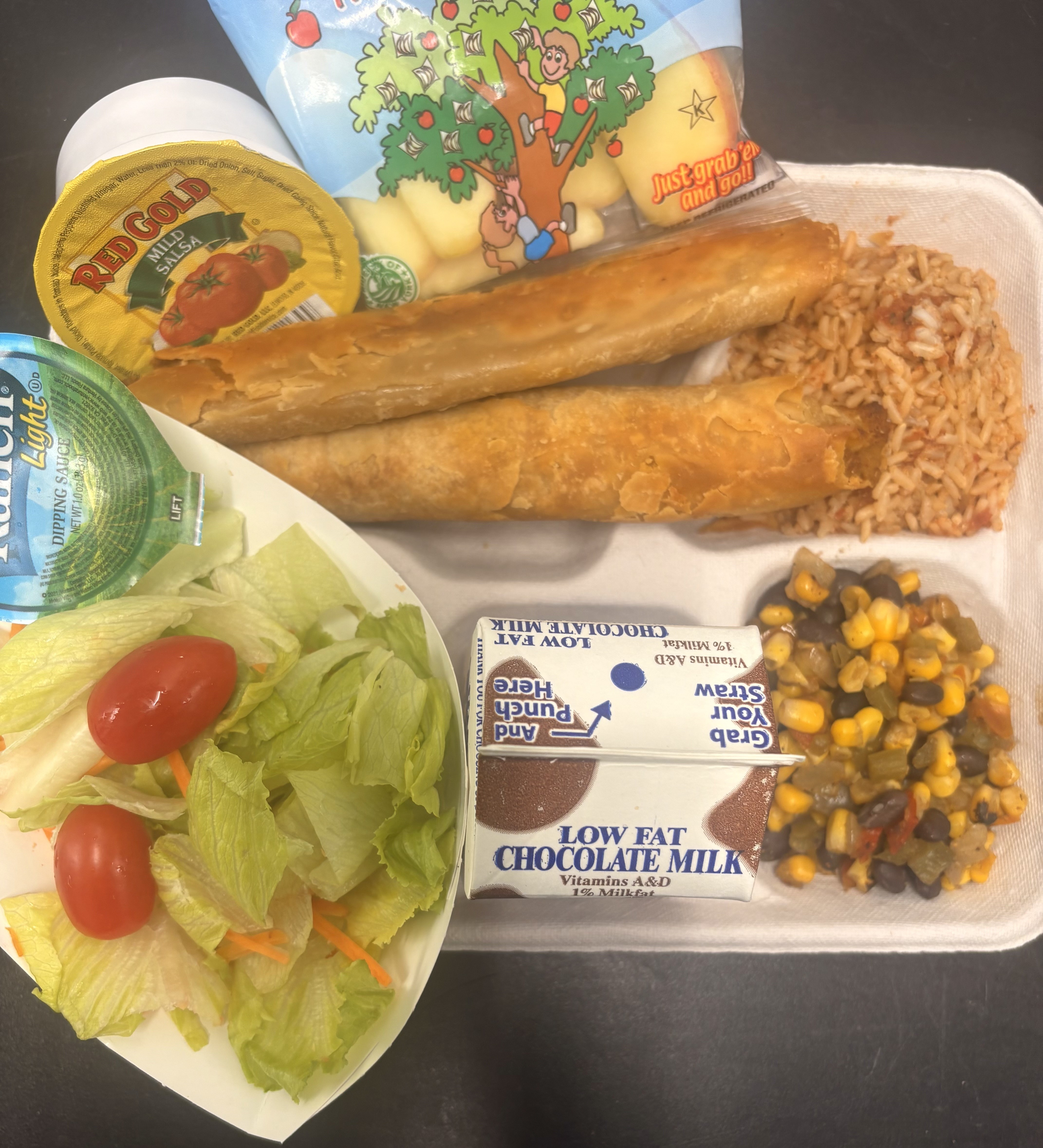 School 50 Lunch served on 10.7.2025 Chicken Crispito, Spanish Rice, Esquites, Salsa, Garden Salad, Apple Slices & Chocolate Milk