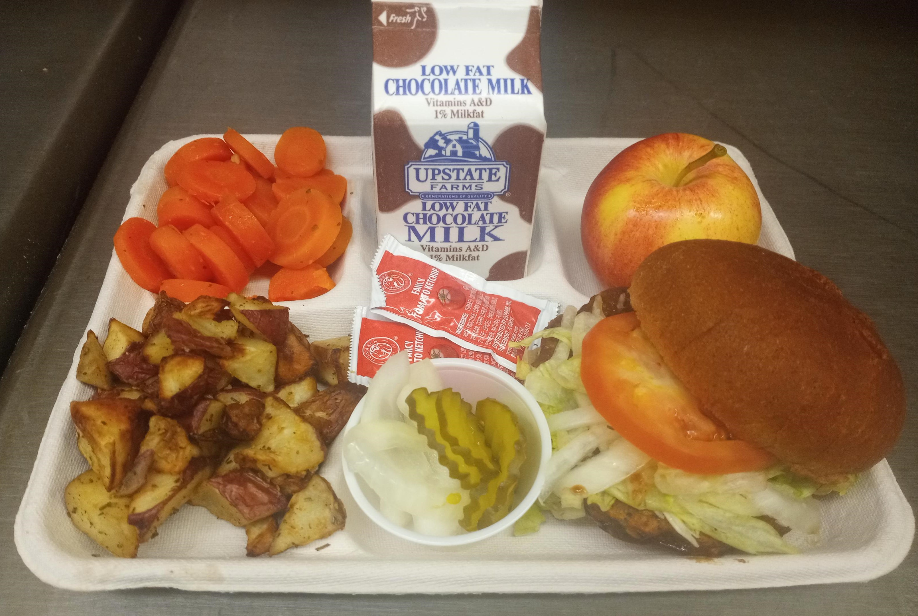 School 207- Lunch served on 10.8.25 Halal Burger, Roasted Potatoes, Coin Carrots, Apple & Chocolate milk