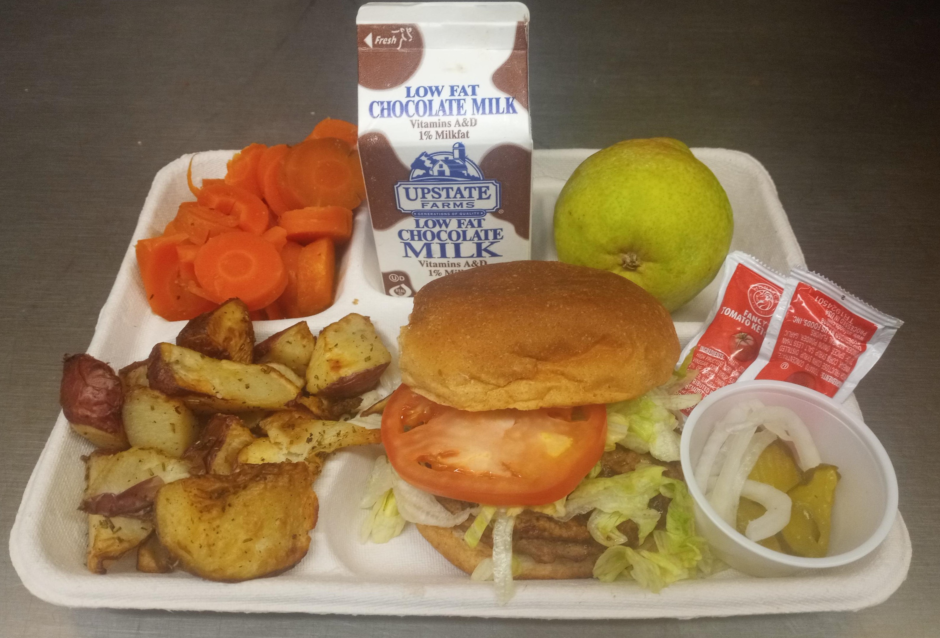 School 207- Lunch served on 10.8.25 Black Bean Burger, Roasted Potatoes, Coin Carrots, Pear & Chocolate milk