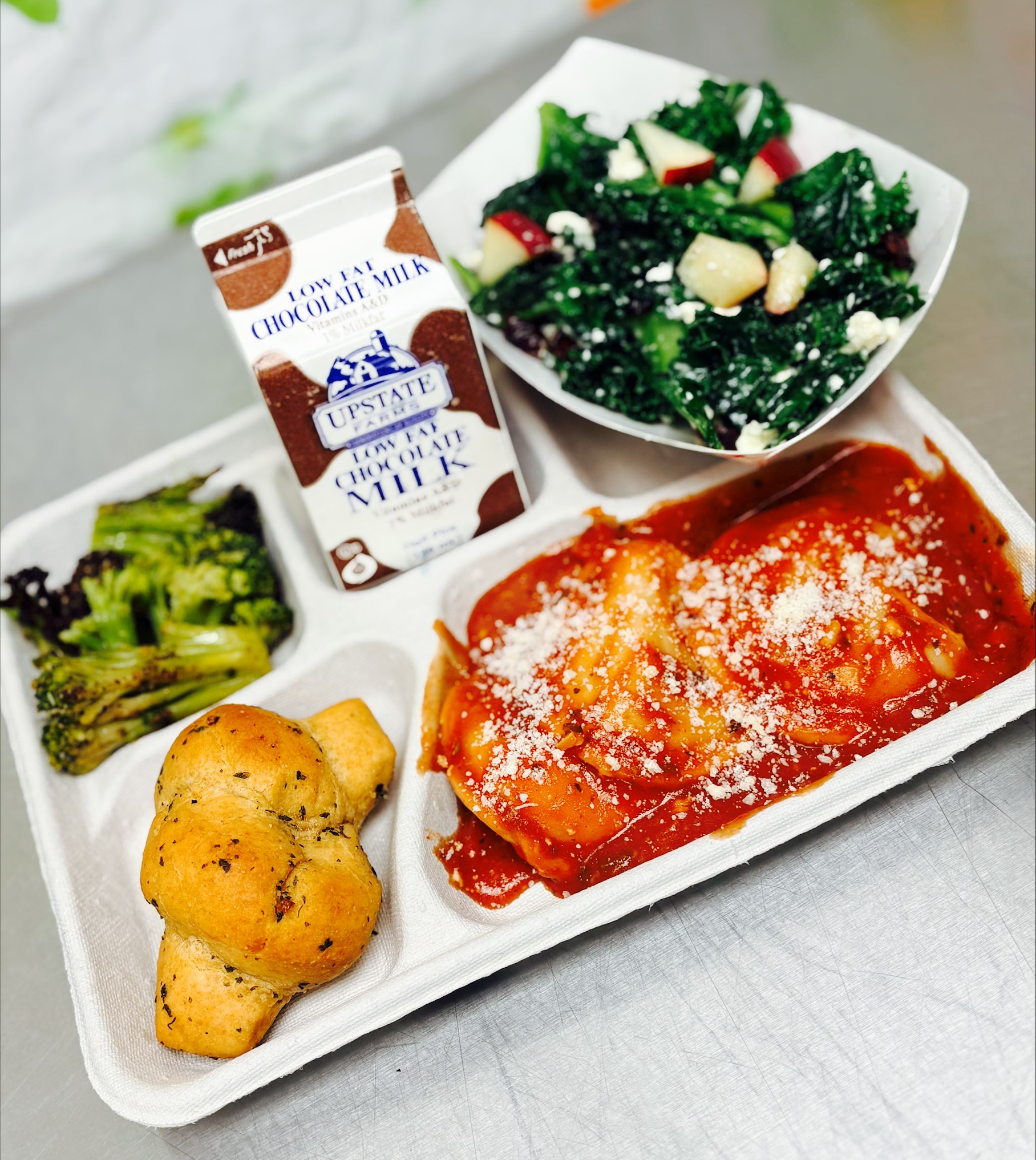 School 198- Lunch served on 10.9.25 Cheese Ravioli, Garlic Knot, NY Kale with Apples, Garlic Parmesan Roasted Broccoli & Cholocale Milk