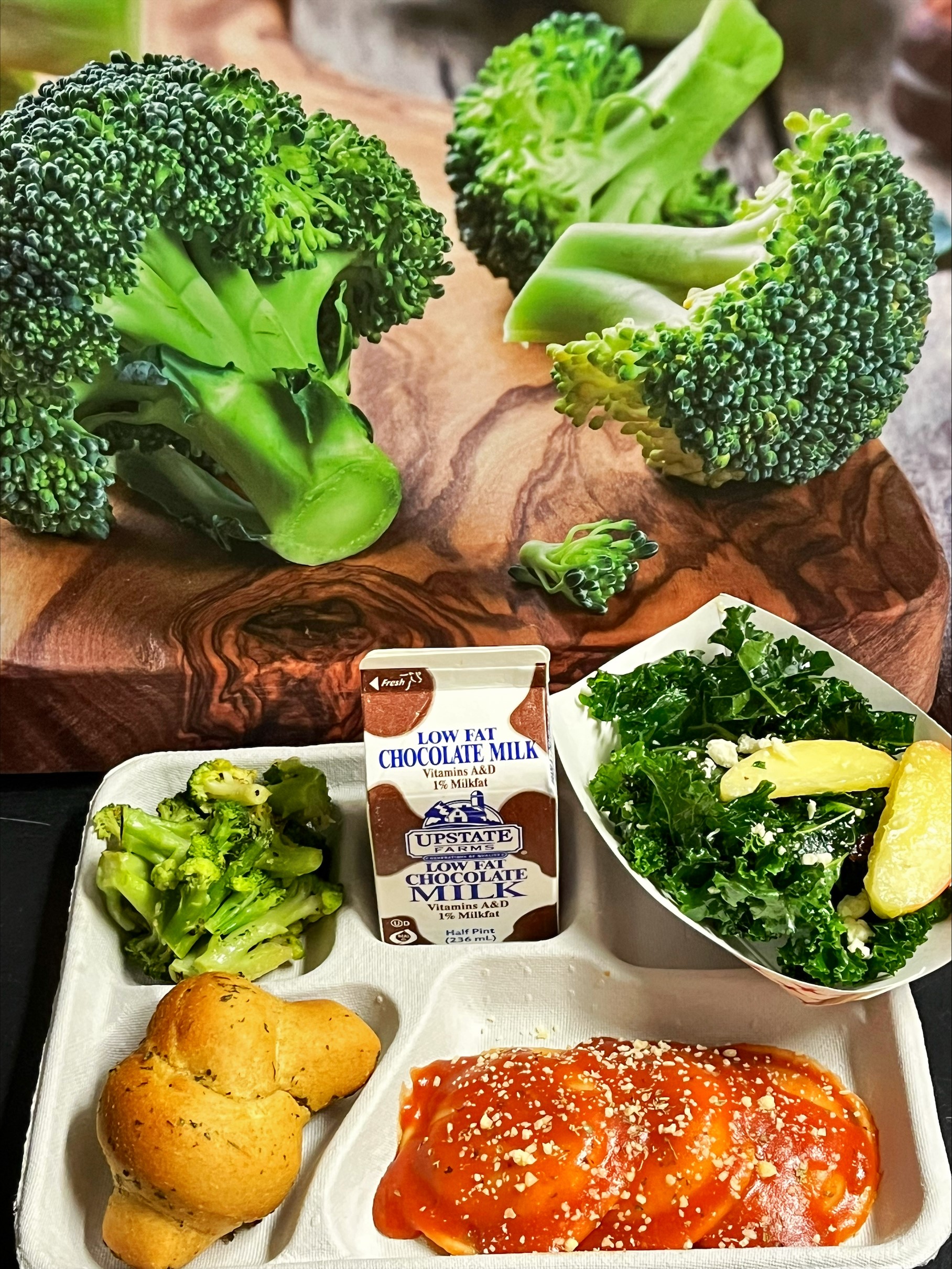 School 205- Lunch served on 10.9.25 Cheese Ravioli, Garlic Knot, Garlic Parmesan Roasted Broccoli, Kale Salad with Apples & Chocolate Milk