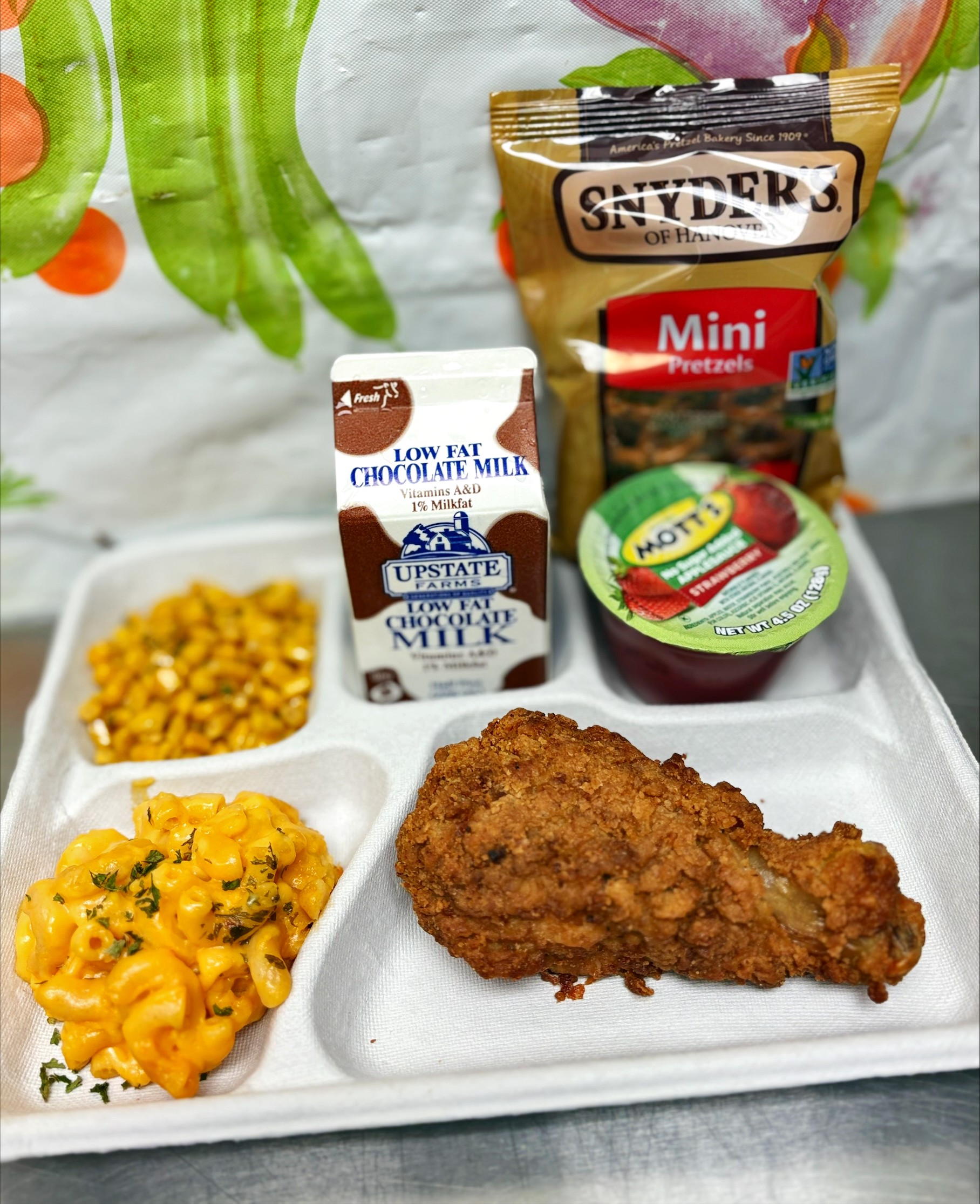 School 198- Lunch served on 10.23.25 Breaded Chicken Drumstick, Macaroni & Cheese, Sweet Corn, Pretzels, Strawberry Applesauce & Chocolate Milk