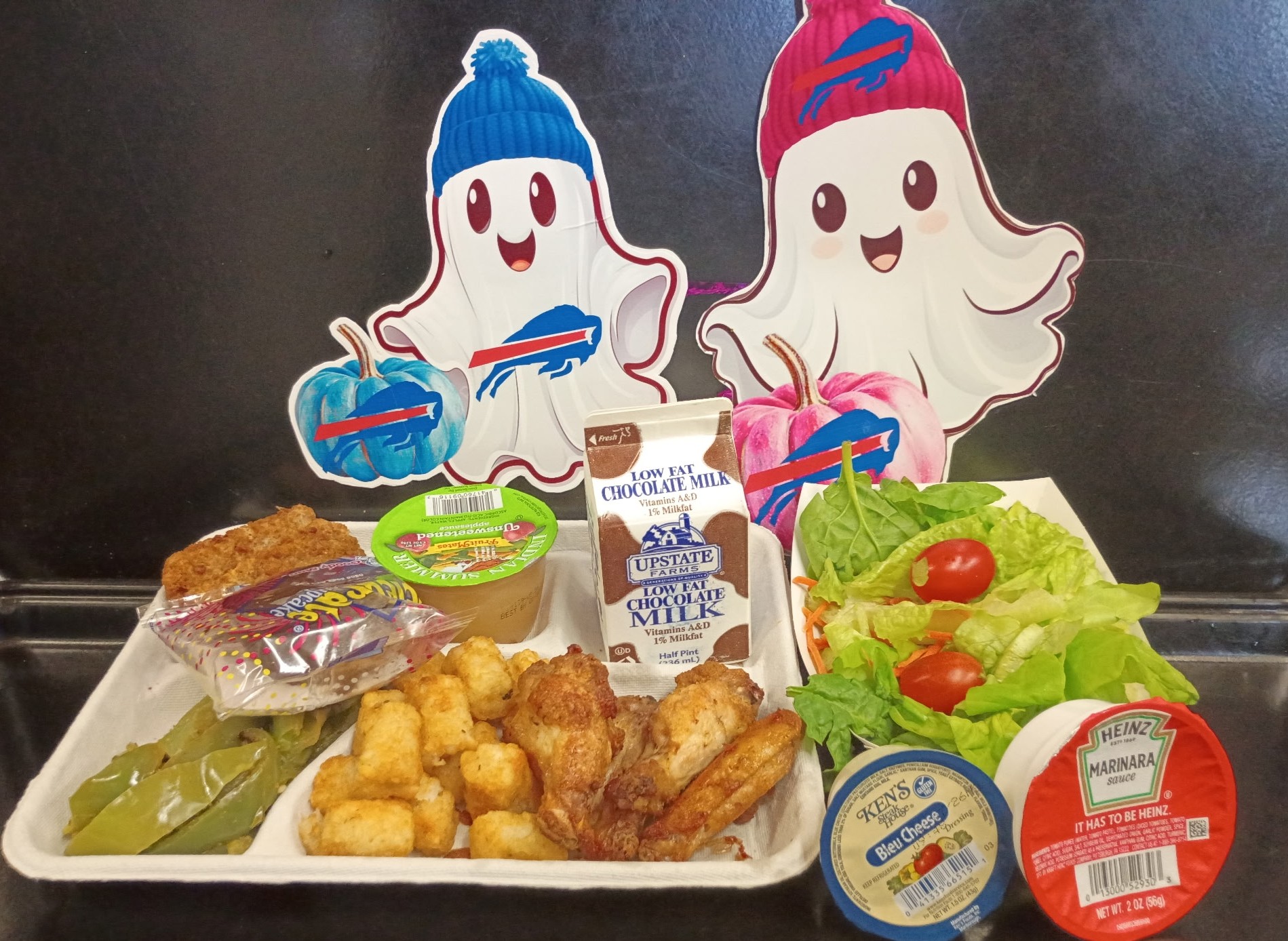 School 207- Lunch served on 10.24.25 Chicken Wings, Pizza Crunchers, Tater Tots, Peppers, Garden Salad, Apple Sauce, Birthday Cake Bar, Chocolate Milk