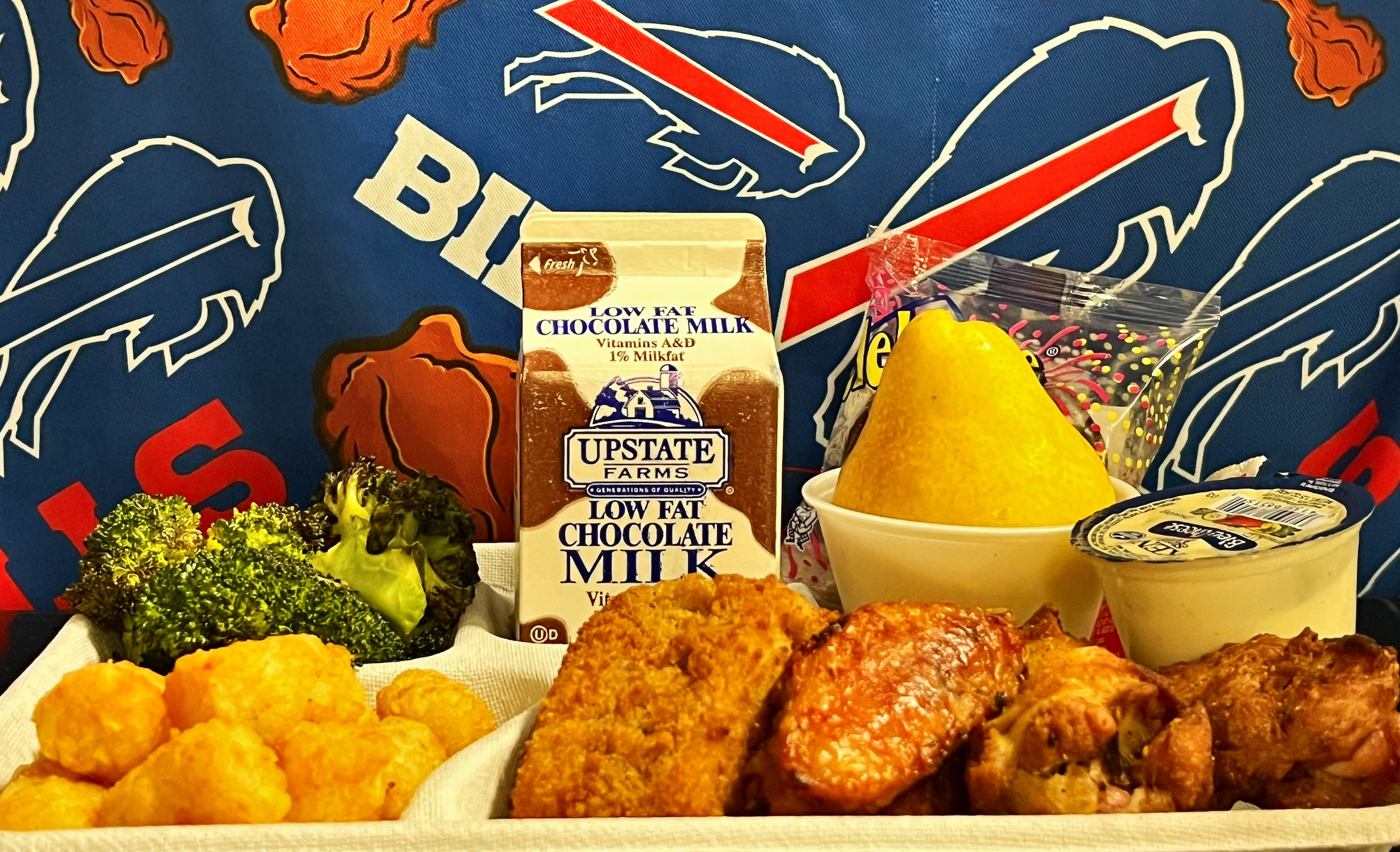 School 208- Lunch served on 10.24.25 Chicken Wings, Pizza Crunchers, Tater Tots, Roasted Broccoli, Pear, Creme Filled Chocolate Cupcake, Chocolate Milk