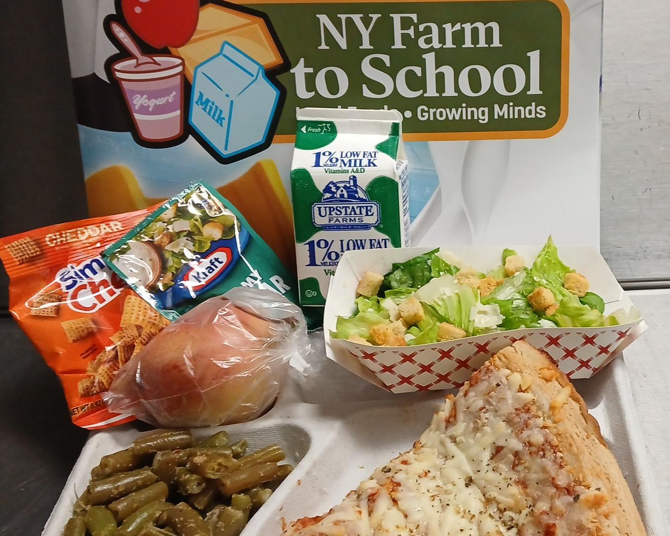 School 59- Lunch served on 10.27.25 Four Cheese Pizza, Caesar Salad, Green Beans, Cheddar Simply Chex, Peach and Milk