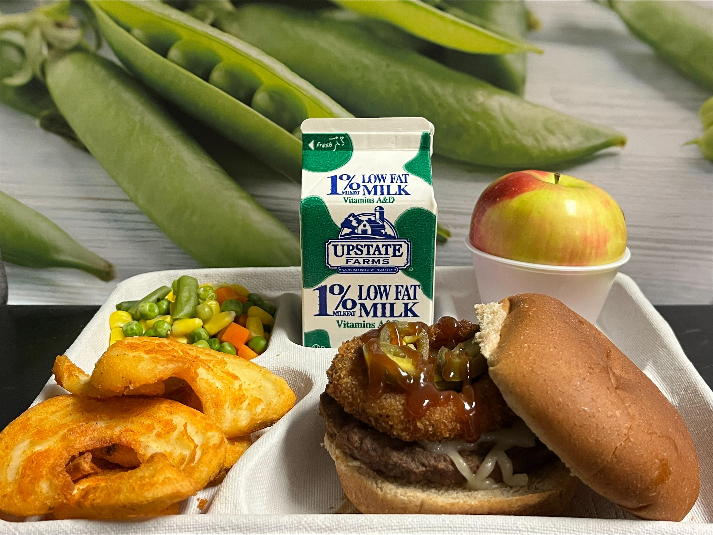 School 208- Lunch served on 10.28.25 Rodeo Burger WG Burger bun, Twister Taters, Vegetable Medley, Apple and Chocolate Milk