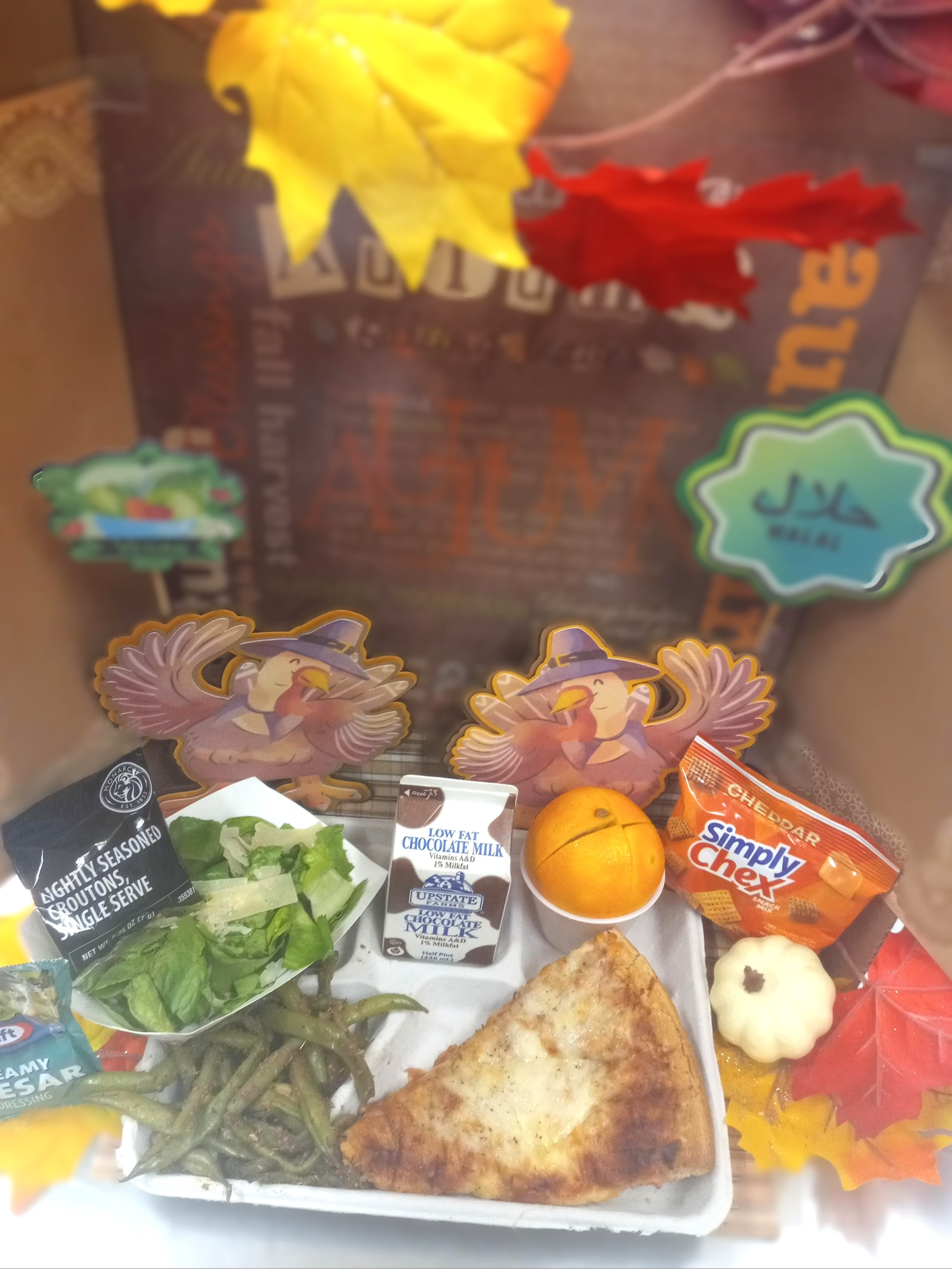 School 207- Lunch served on 11.10.25 Four Cheese Pizza, Green Beans, Caesar Salad, Cheddar Chex Mix, Orage and Chocolate Milk