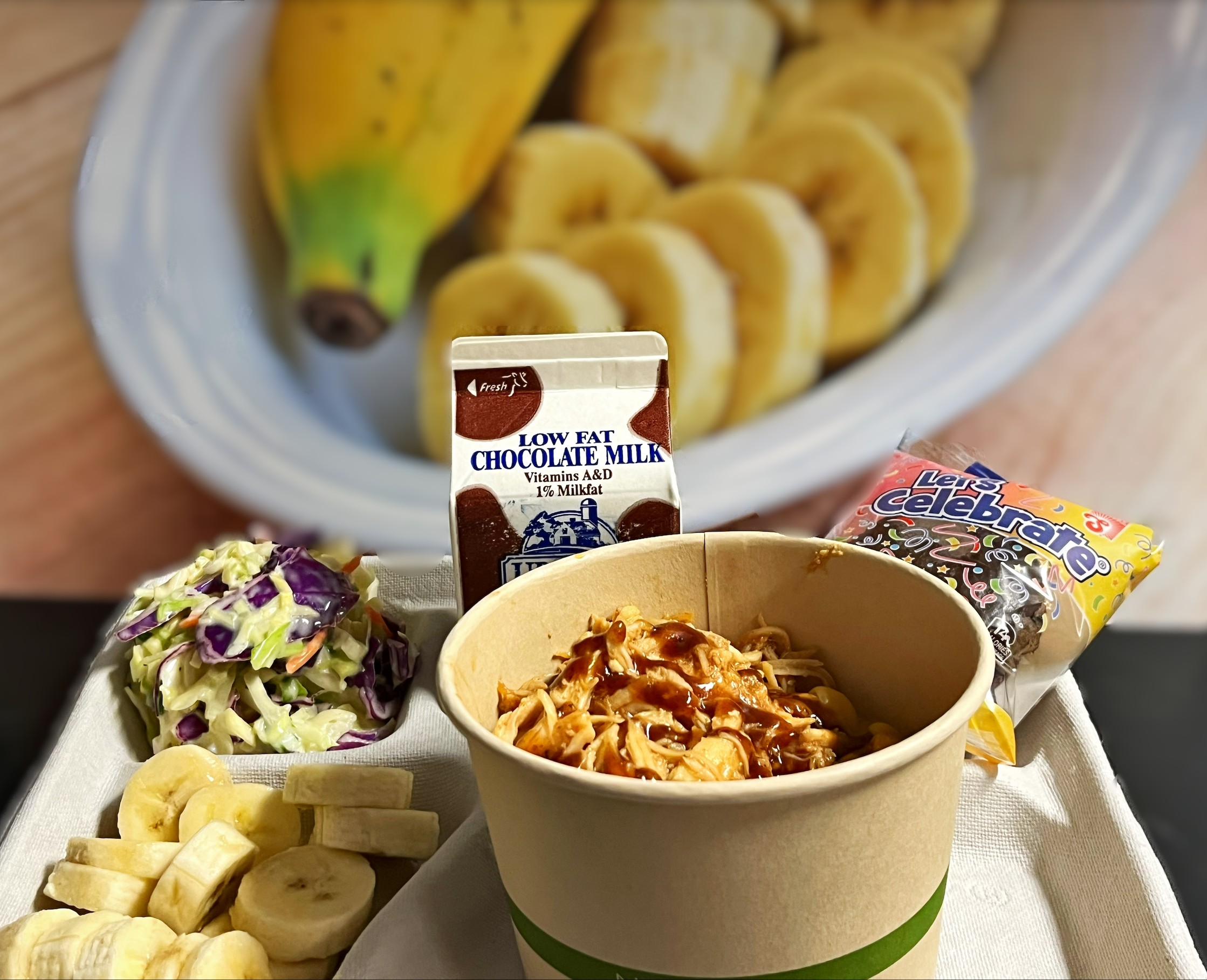 School 208- 2.11.26 BBQ Pulled Chicken Mac and Cheese Bowl, Garlic Parmesan, Cole slaw, Bananas, Chocolate Cupcake and Chocolate Milk 