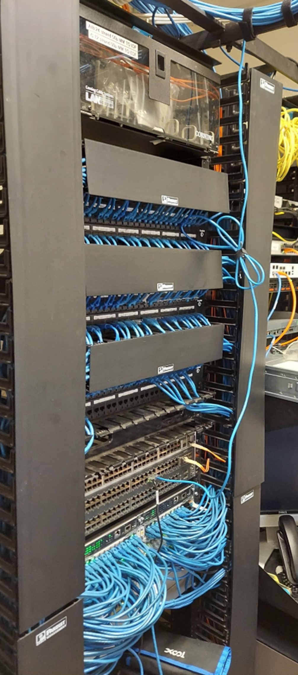 A server rack filled with neatly organized blue and yellow Ethernet cables