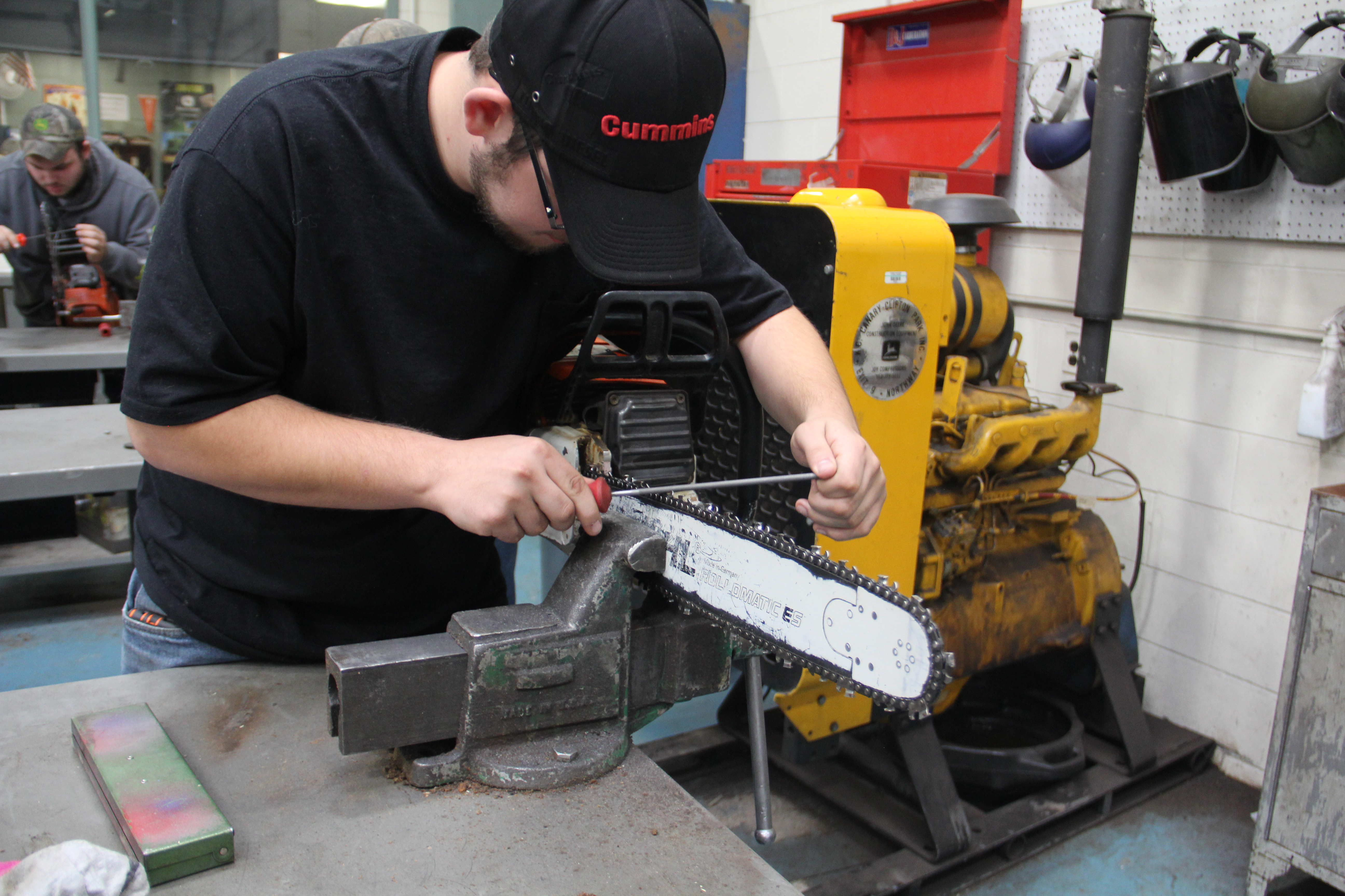 A man was holding a screw driver while grinding it in a saw