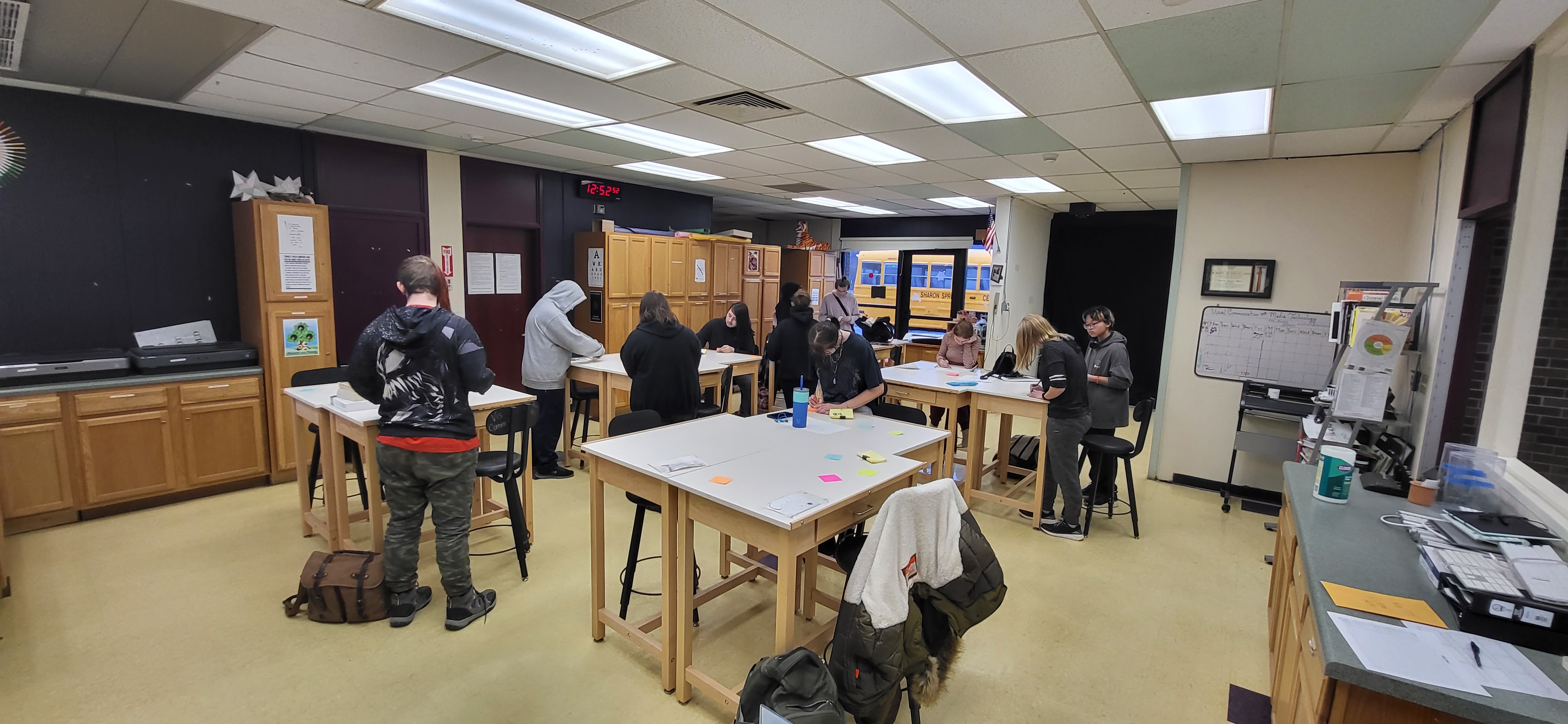 A group of people gathered in a well-lit classroom