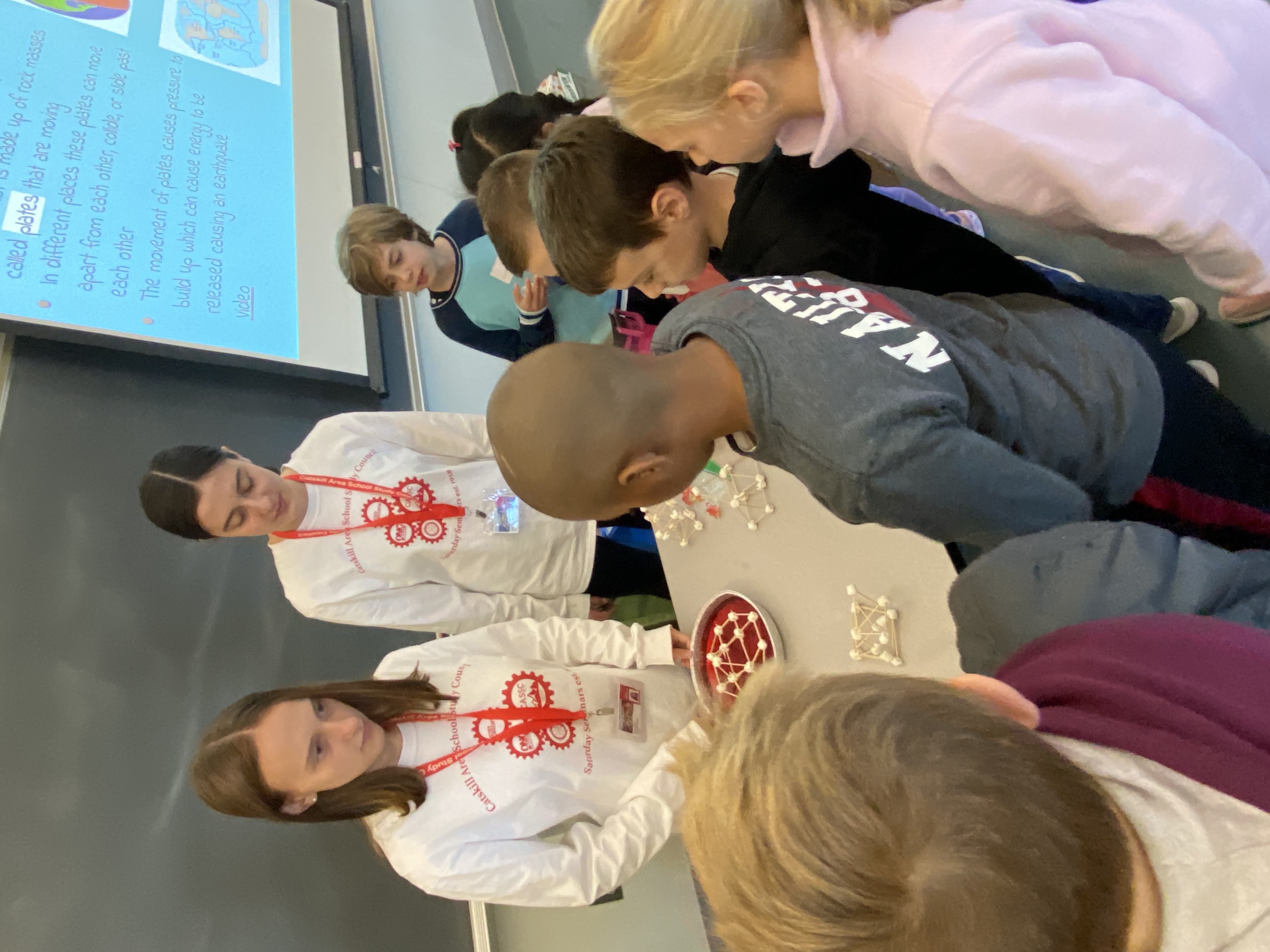 A group of children engaging with instructors in a classroom setting