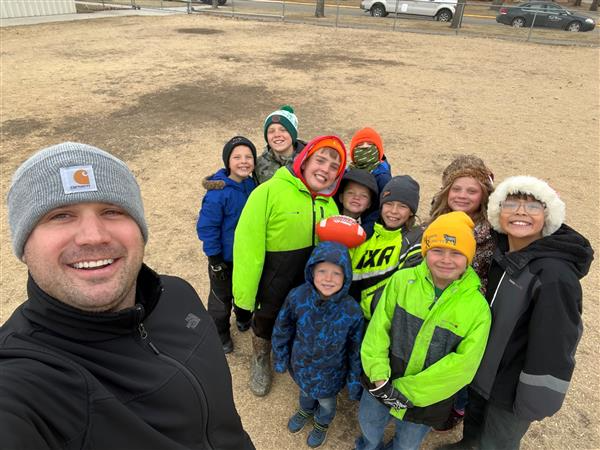 A group of friends smiling and taking a selfie in the snow during a fun winter day out.